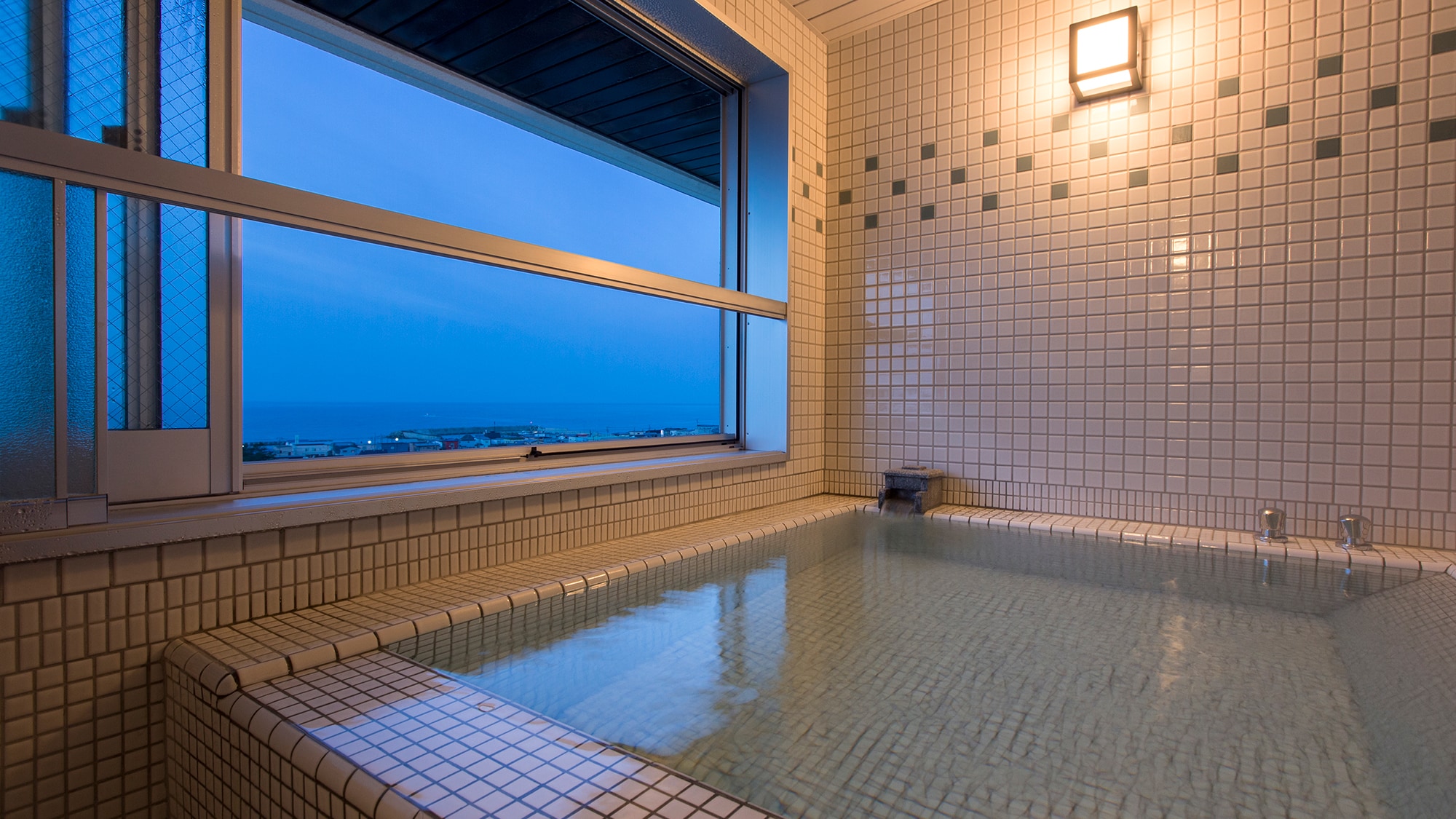 [Taisho Romantic: An example of a guest room panoramic bath] Decorative tiles and lighting, along with the night view of Hakodate, create a nostalgic space.