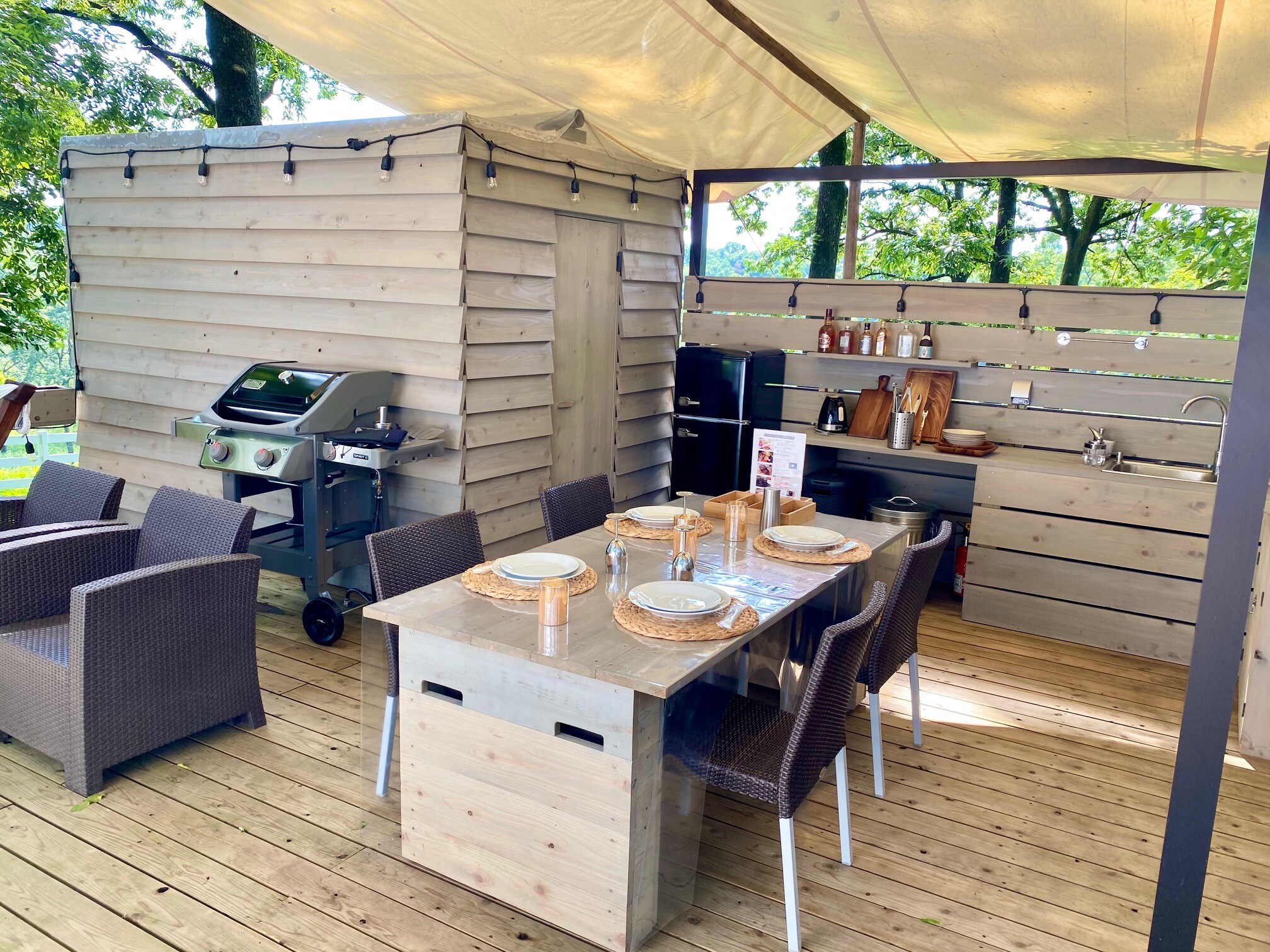 The BBQ dining area is equipped with cooking utensils, seasonings, and a Weber grill. The refrigerator also stocks alcohol and ice cubes.