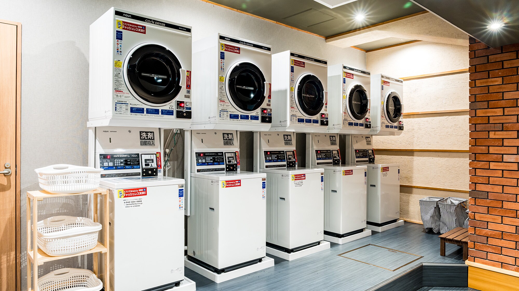 [Coin Laundry] Newly installed on the 2nd floor of the building. A clean room with rows of washing machines and dryers.