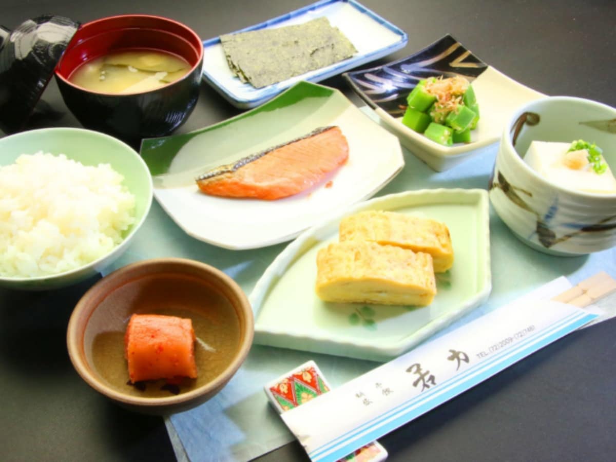 Savory grilled fish and fluffy rolled eggs with steaming hot, freshly cooked rice for a luxurious morning.