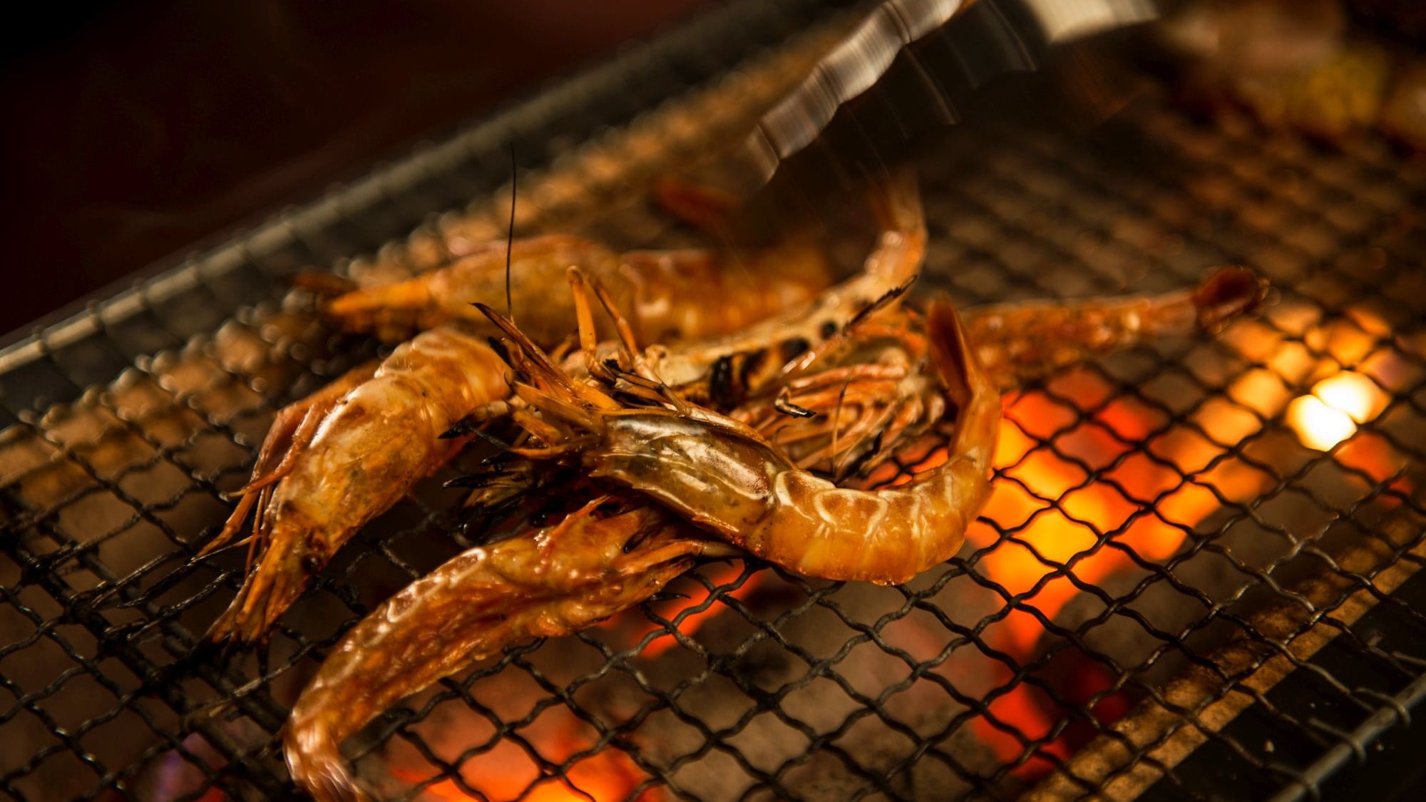[Prasmanan Shonai Mokke] Pojok makanan panggang. Makanan seperti udang gasa dan sate babi dipanggang tepat di depan Anda di atas arang asli.