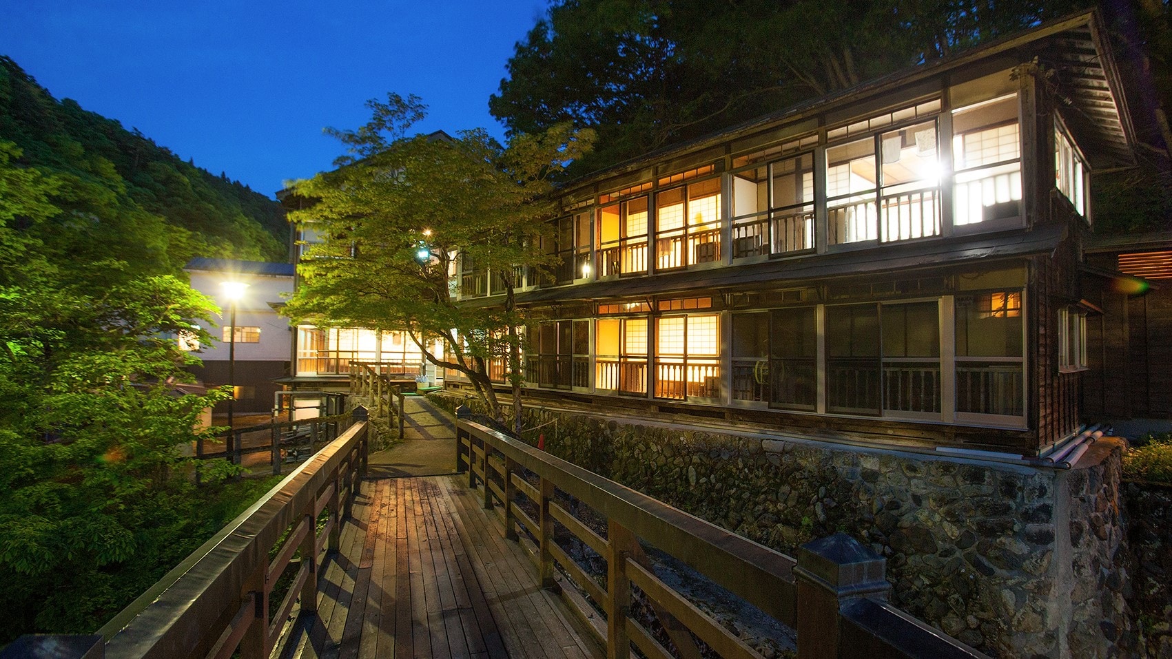 View of the hot springs resort from the curved bridge at dusk
