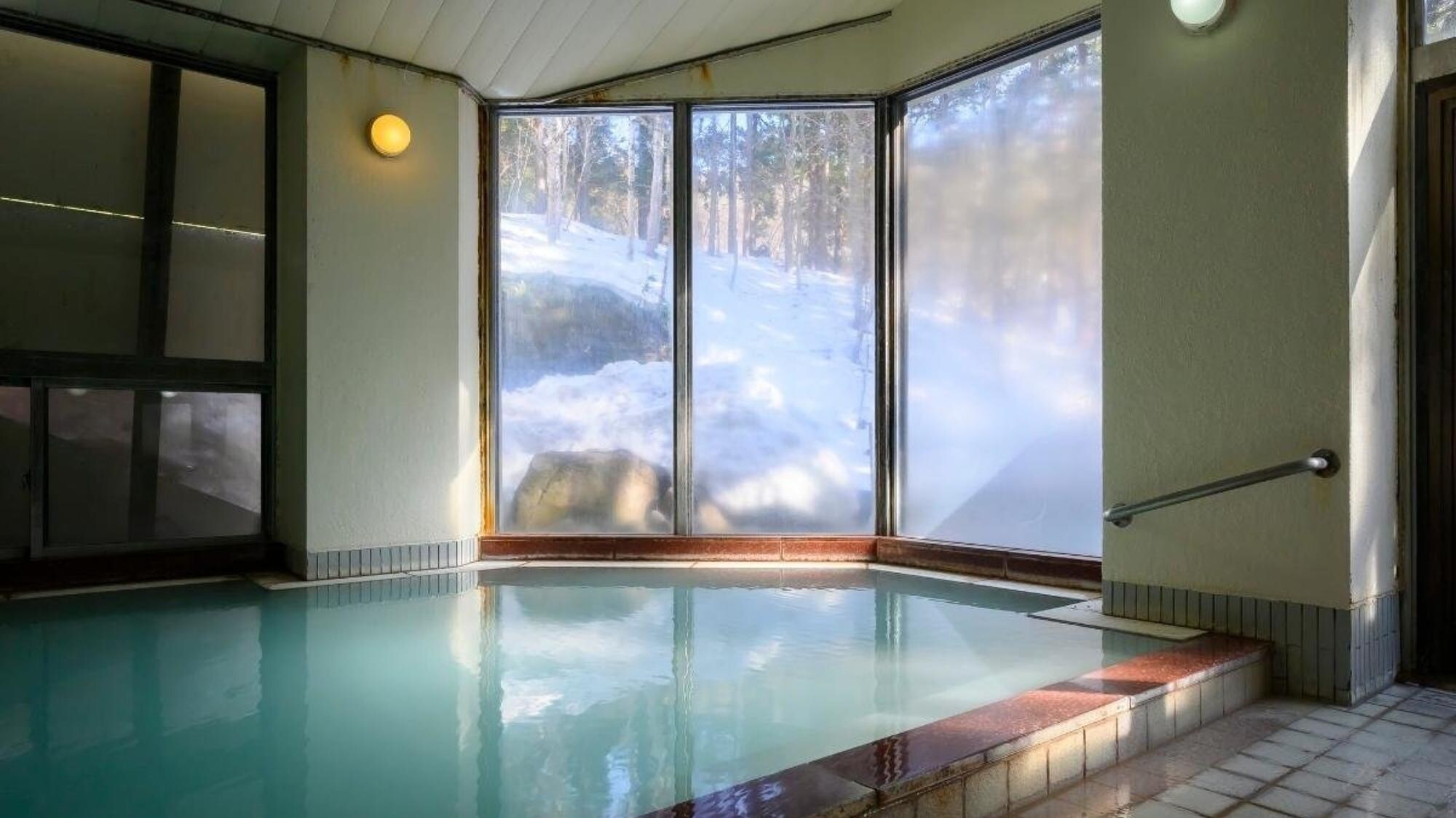 ห้องอาบน้ำสาธารณะขนาดใหญ่พร้อมทิวทัศน์ธรรมชาติจากหน้าต่างบานใหญ่