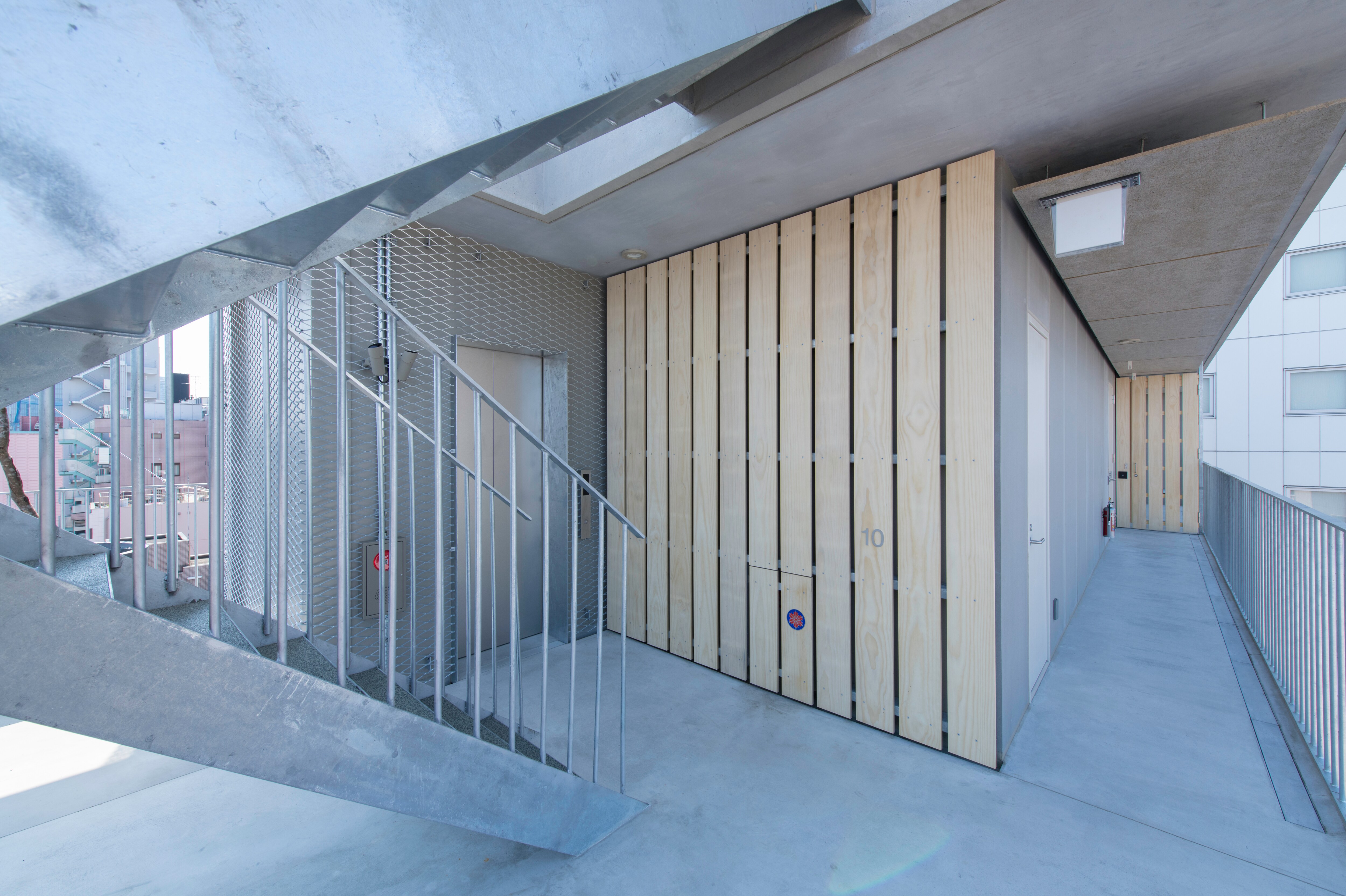 ทางเดินภายนอกแบบเปิดโล่งนำจากลิฟต์ไปยังห้องพัก