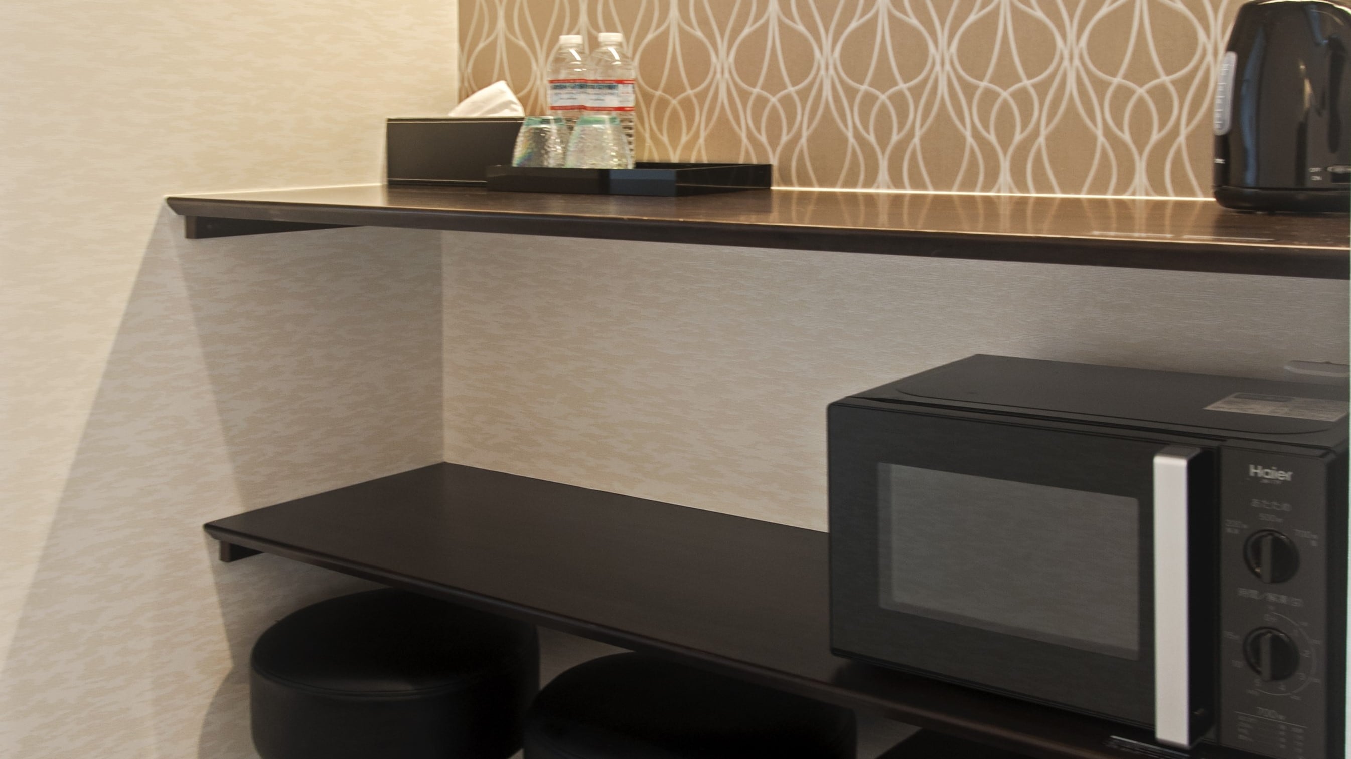 A microwave and a kettle are provided on the counter table.