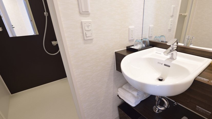 Around the sink, hand soap, toothbrushes, and a hair dryer are provided.