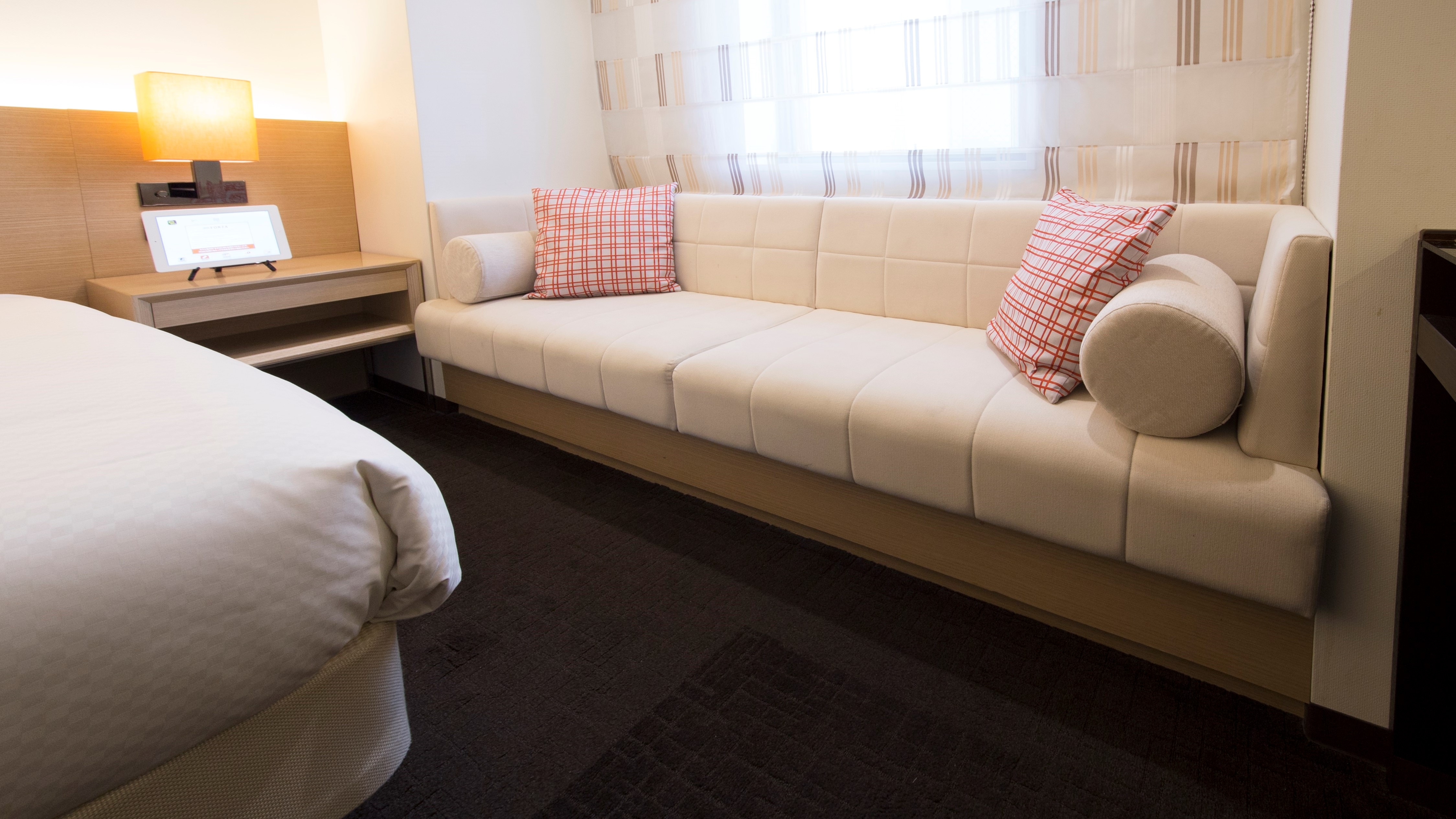 Relax in the "Deluxe Double" room featuring a sofa * The shape of the sofa varies depending on the room15