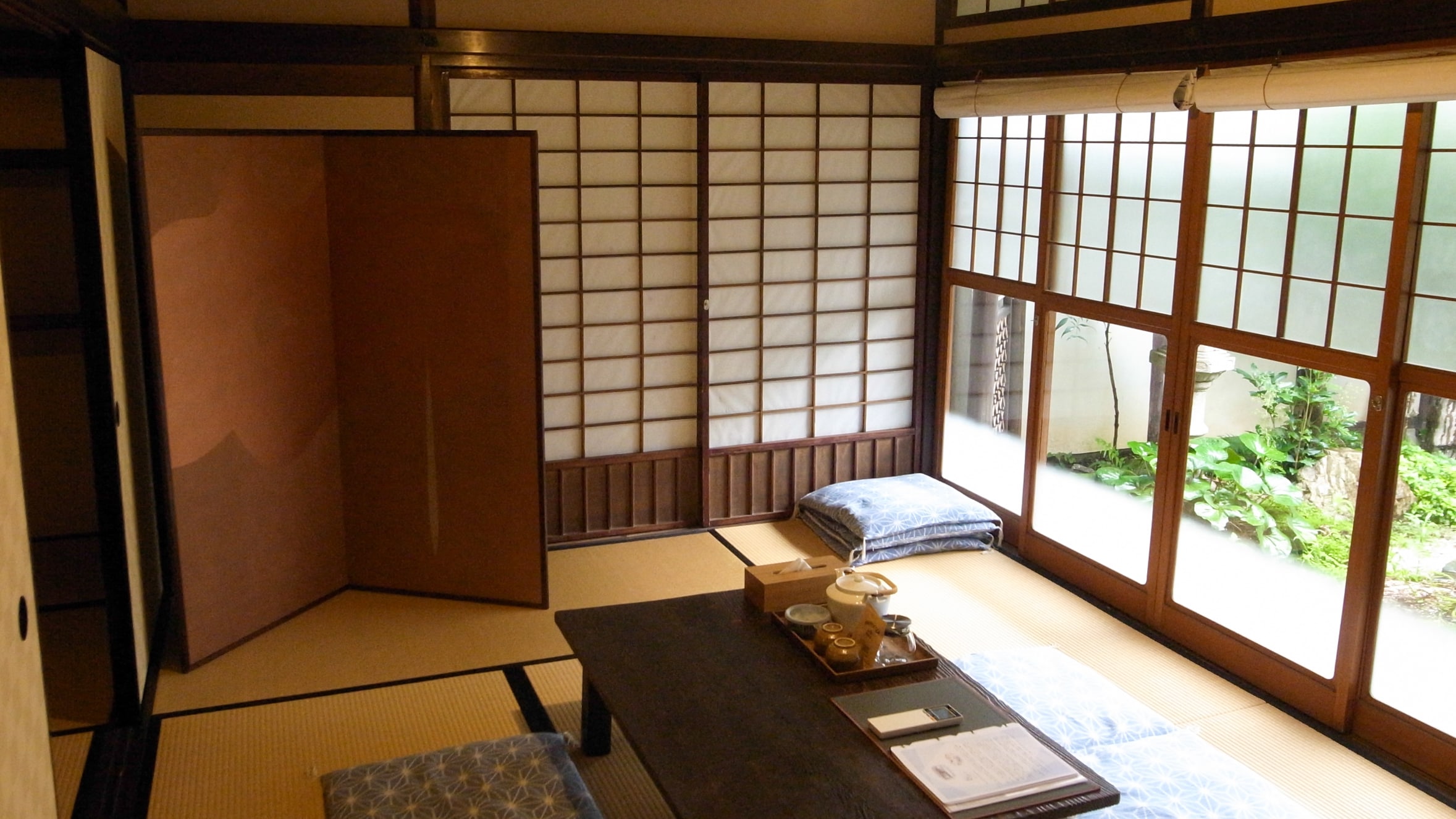 <Yawata no Ma> A six tatami mat room (living room) overlooking the garden on the east side. You can see the old Vories post office right in front of you.