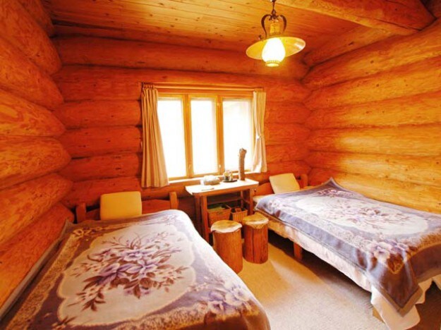[Forest Log Cottage] A bedroom surrounded by logs