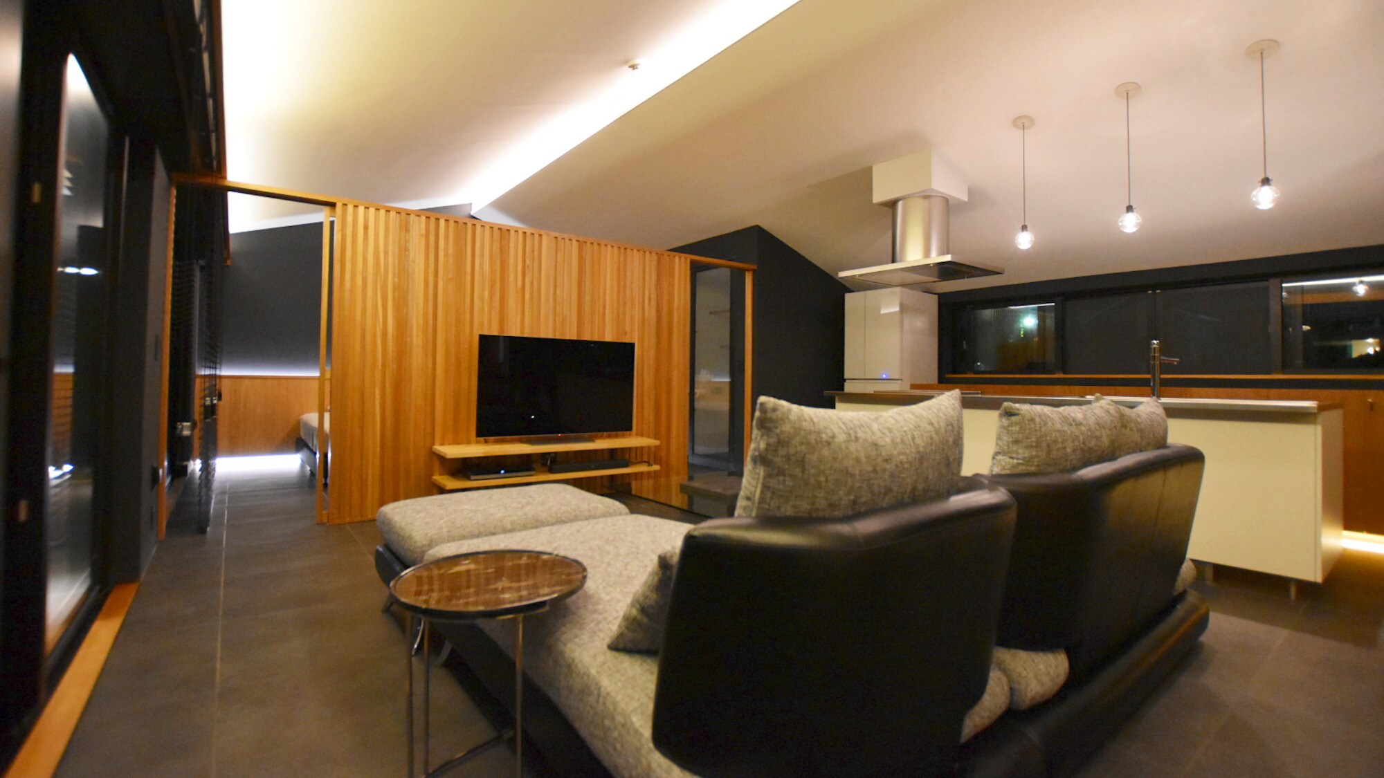 By connecting the rooms together like a one-room apartment, the ceiling panels are offset to accommodate indirect lighting.