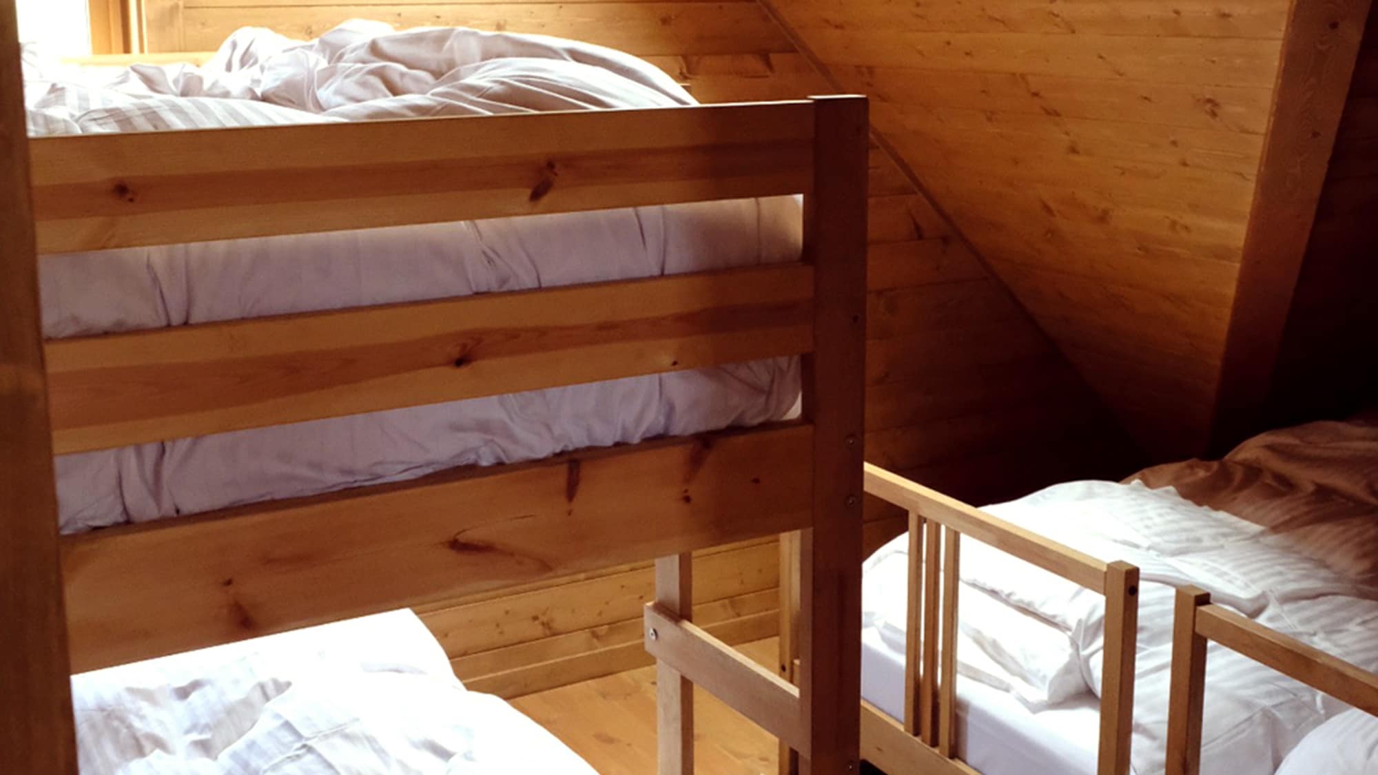 *Example of a guest room: A log cabin-style room with two single beds and one bunk bed.