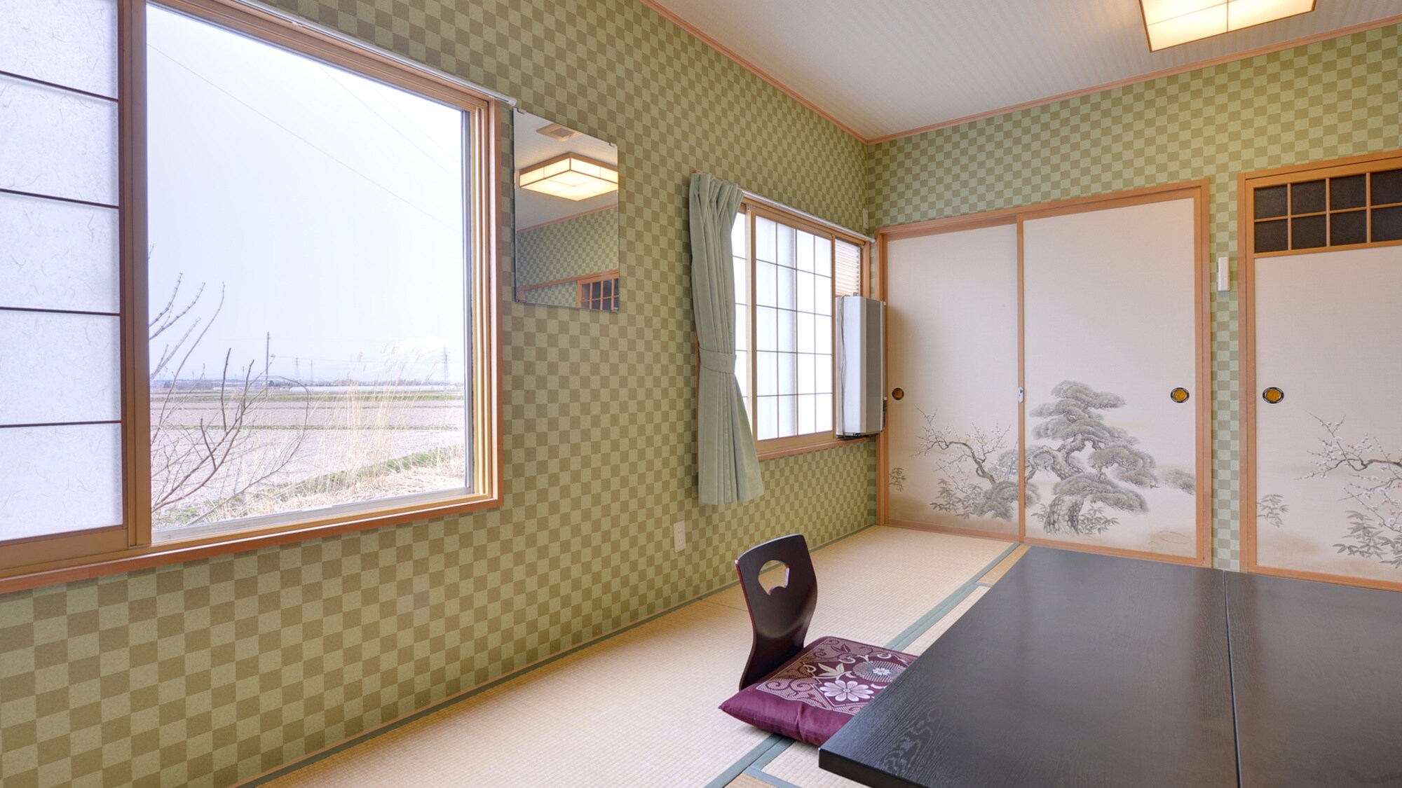 *Japanese-style room of 8 to 10 tatami mats (example of a guest room)/Large windows offer a panoramic view of the endless Tsugaru Plain.