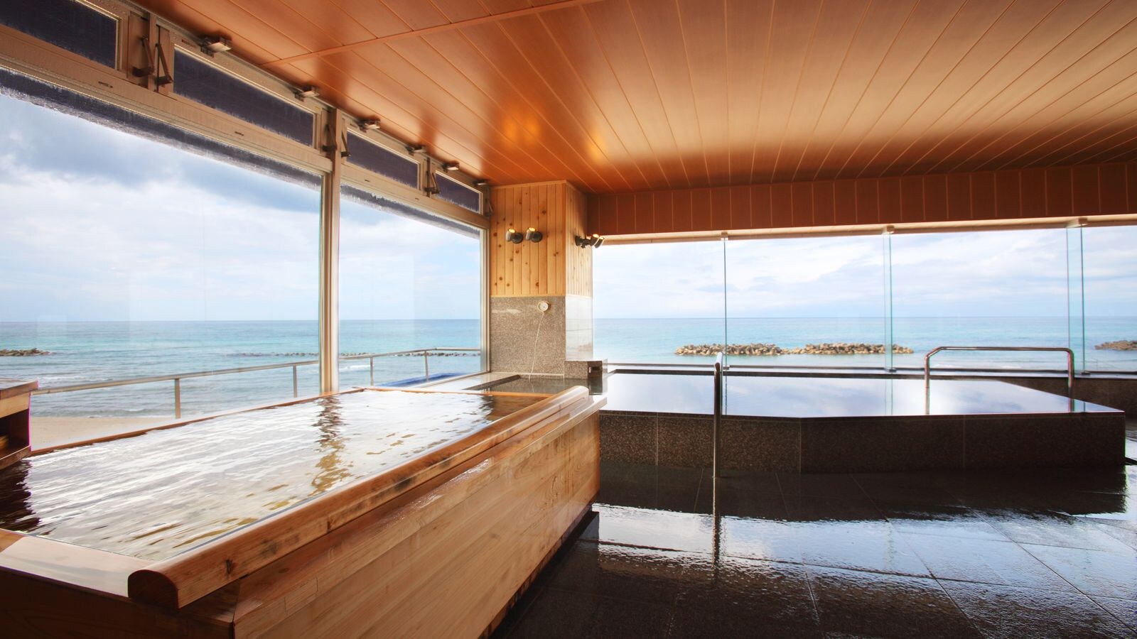 A large bath with a view of the ocean stretching straight to the horizon