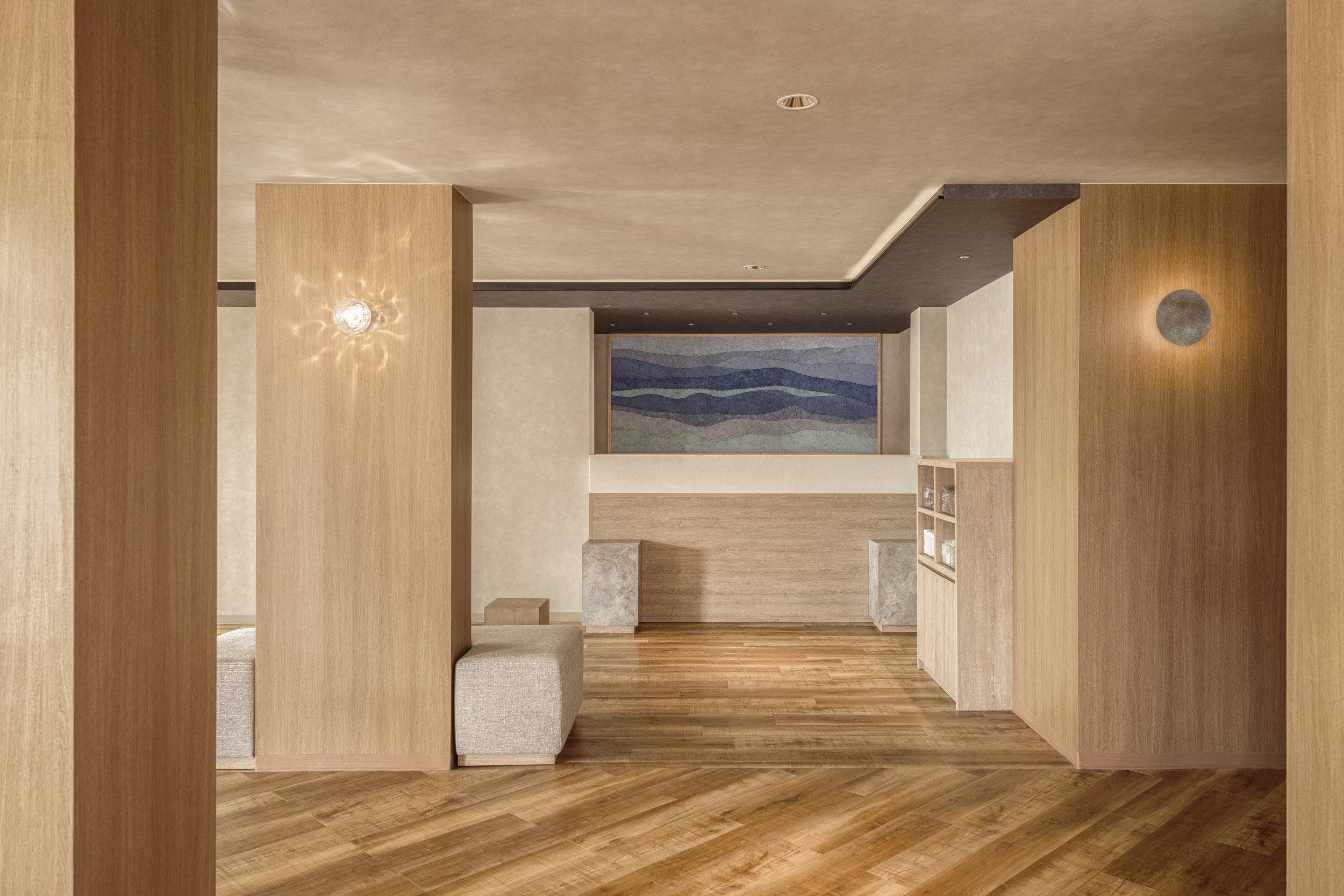 The lobby is unified with wood grain and earthen wall tones, creating a space where you can feel the natural surroundings of the stone walls.