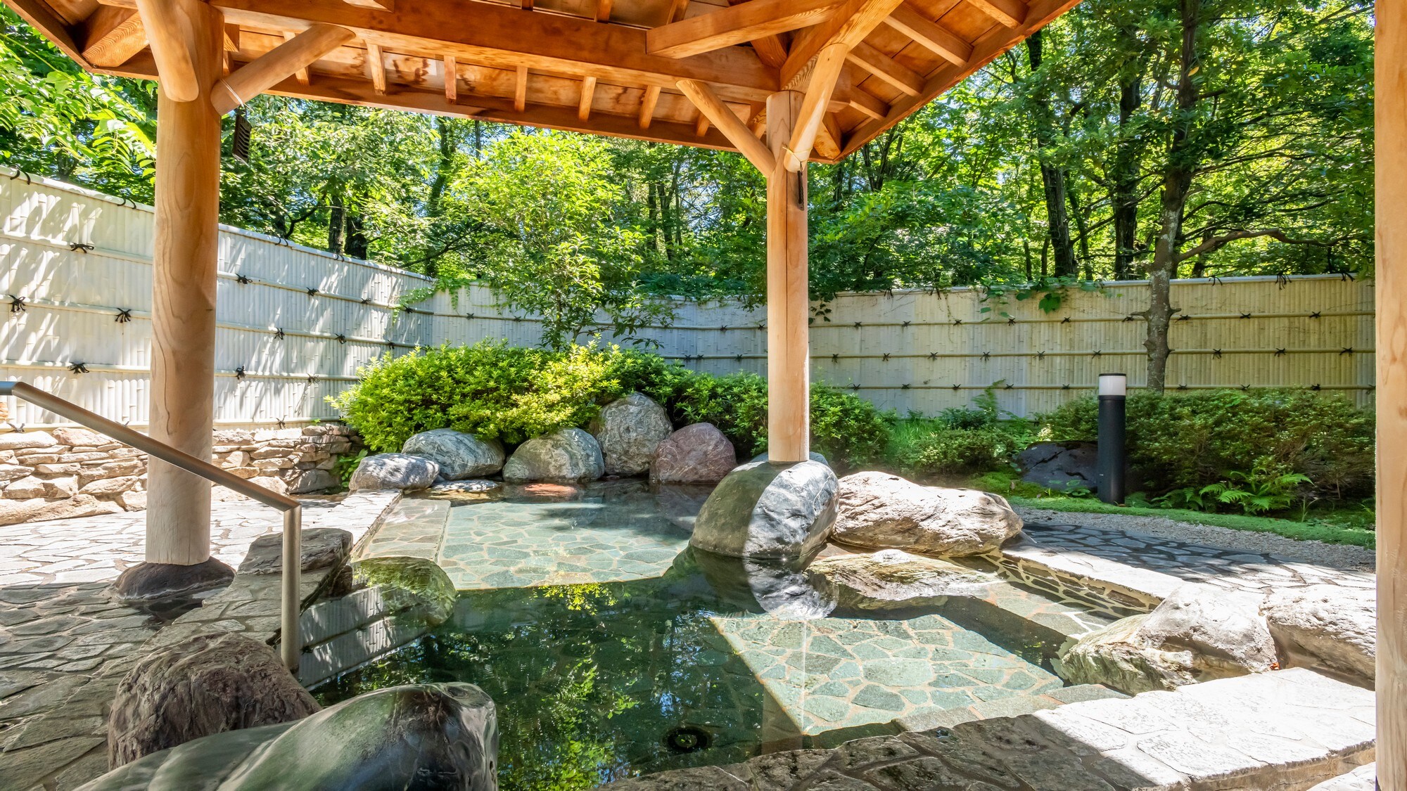 Open-air bath surrounded by green trees