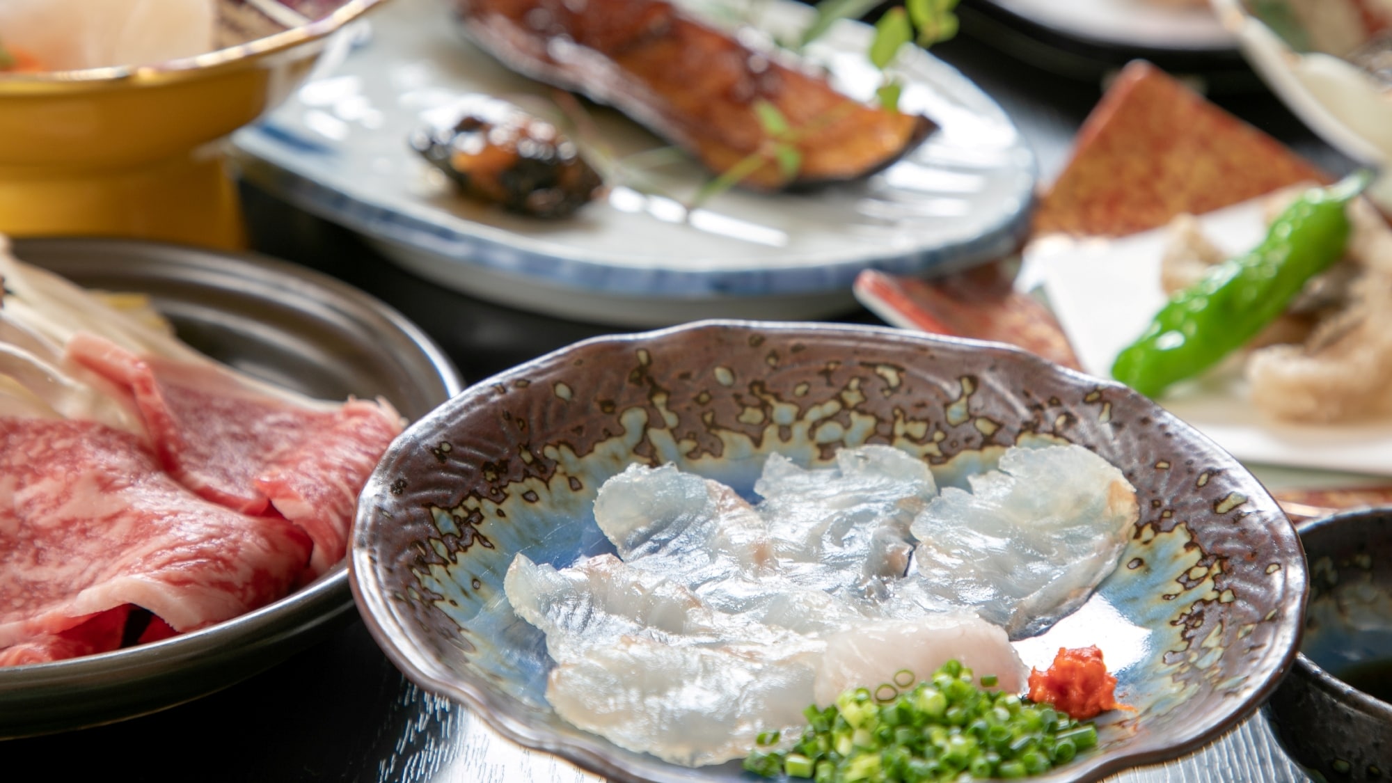 Hãy thưởng thức các món ăn theo mùa như sashimi cá theo mùa (như cá bơn) và thịt bò Saga nướng trên đĩa gốm.