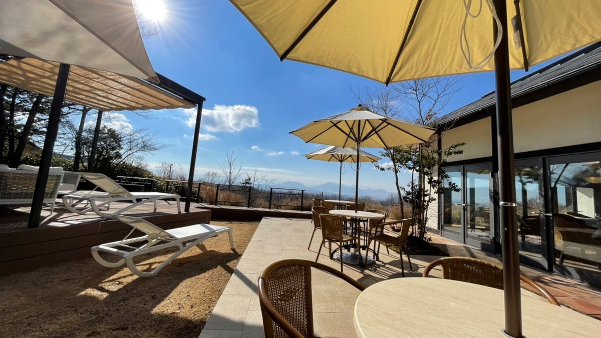 A wooden deck with a panoramic view of the five peaks of Mt. Aso