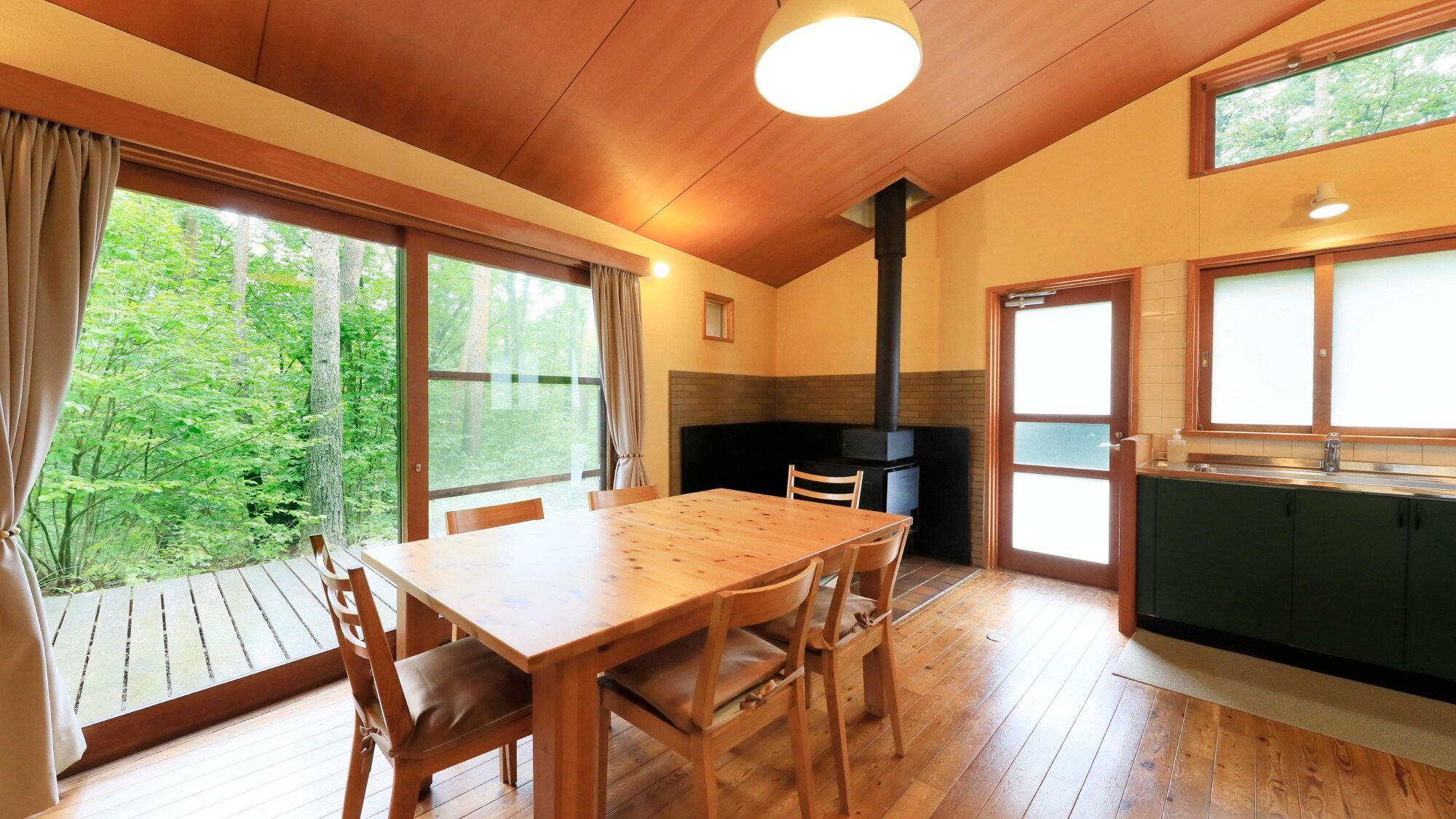 ・Akagera House: A living/dining room with a view of the forest from the large windows
