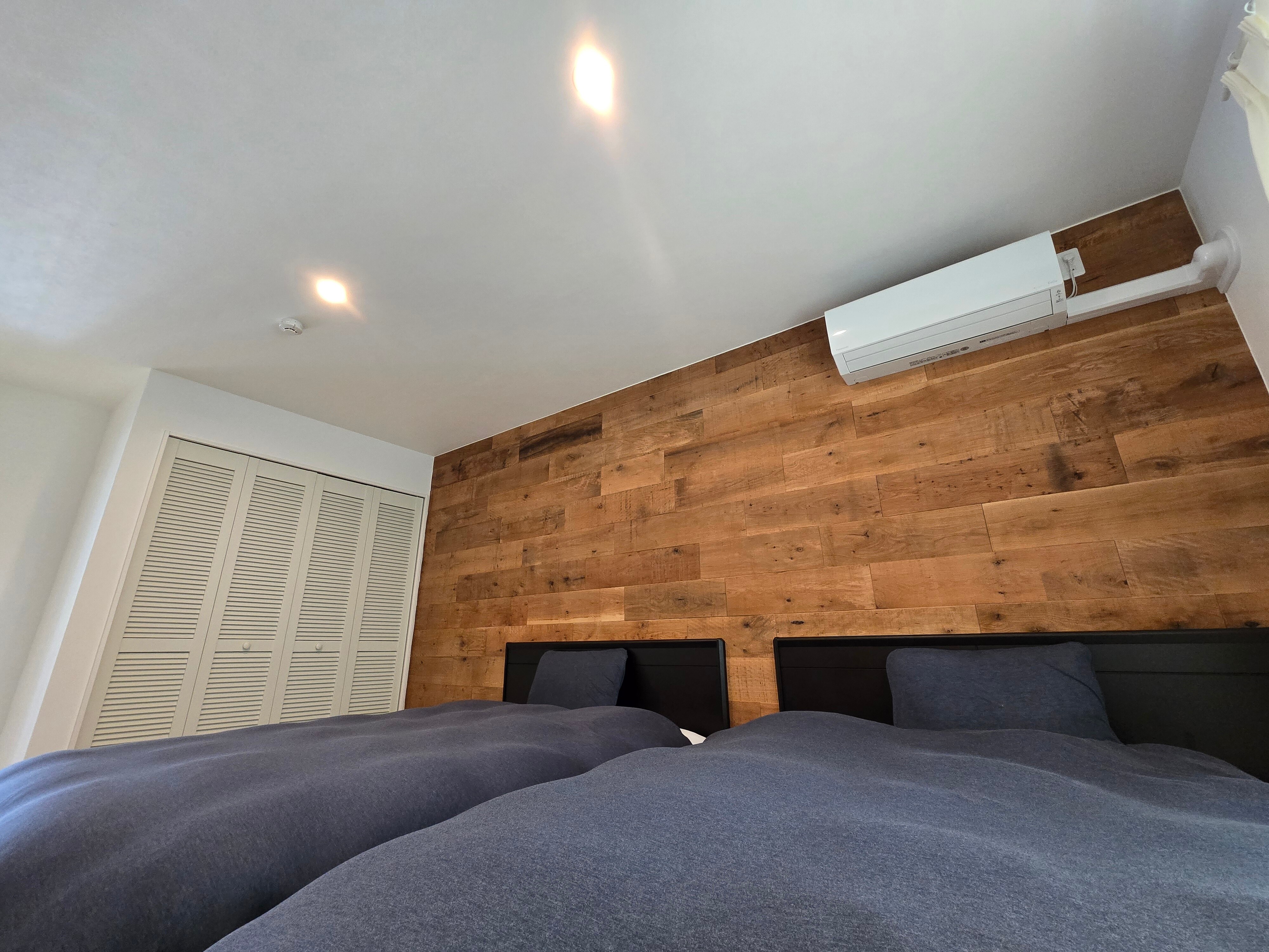 A tranquil bedroom with a wood accent wall.
