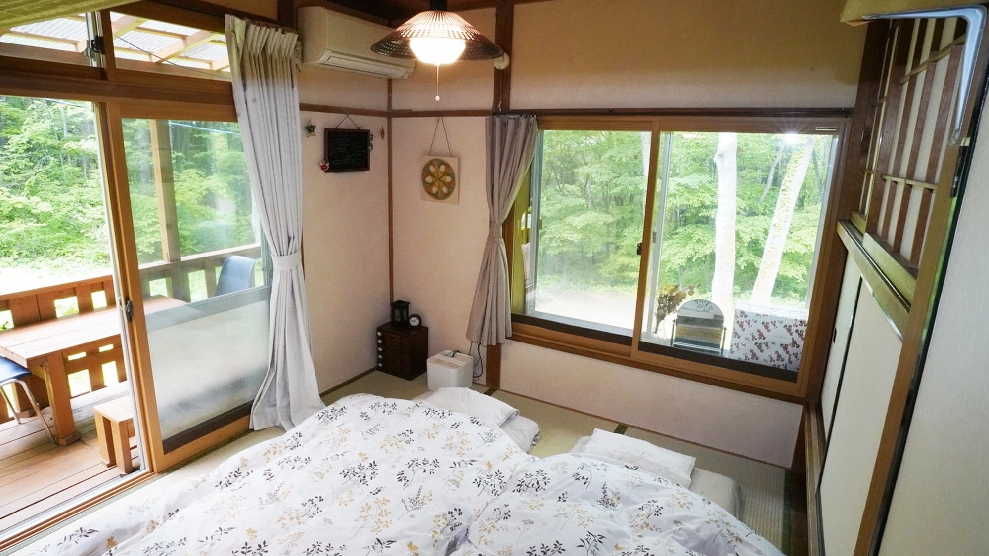 It is a bright and airy Japanese-style room with a view of the forest from the bedroom.