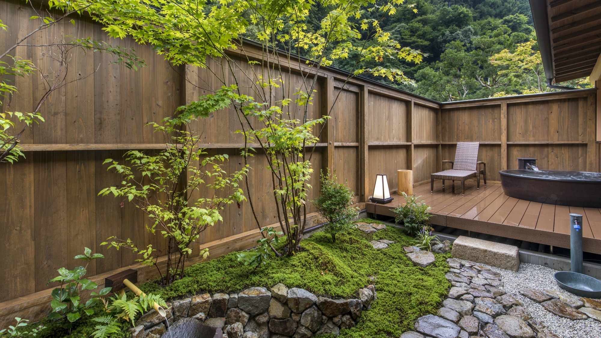 [Japanese-Western Suite] An open-air bath is set up on the wooden deck of the garden that continues from the wide edge, and the bathtub is a special bespoke item baked in Shigaraki.
