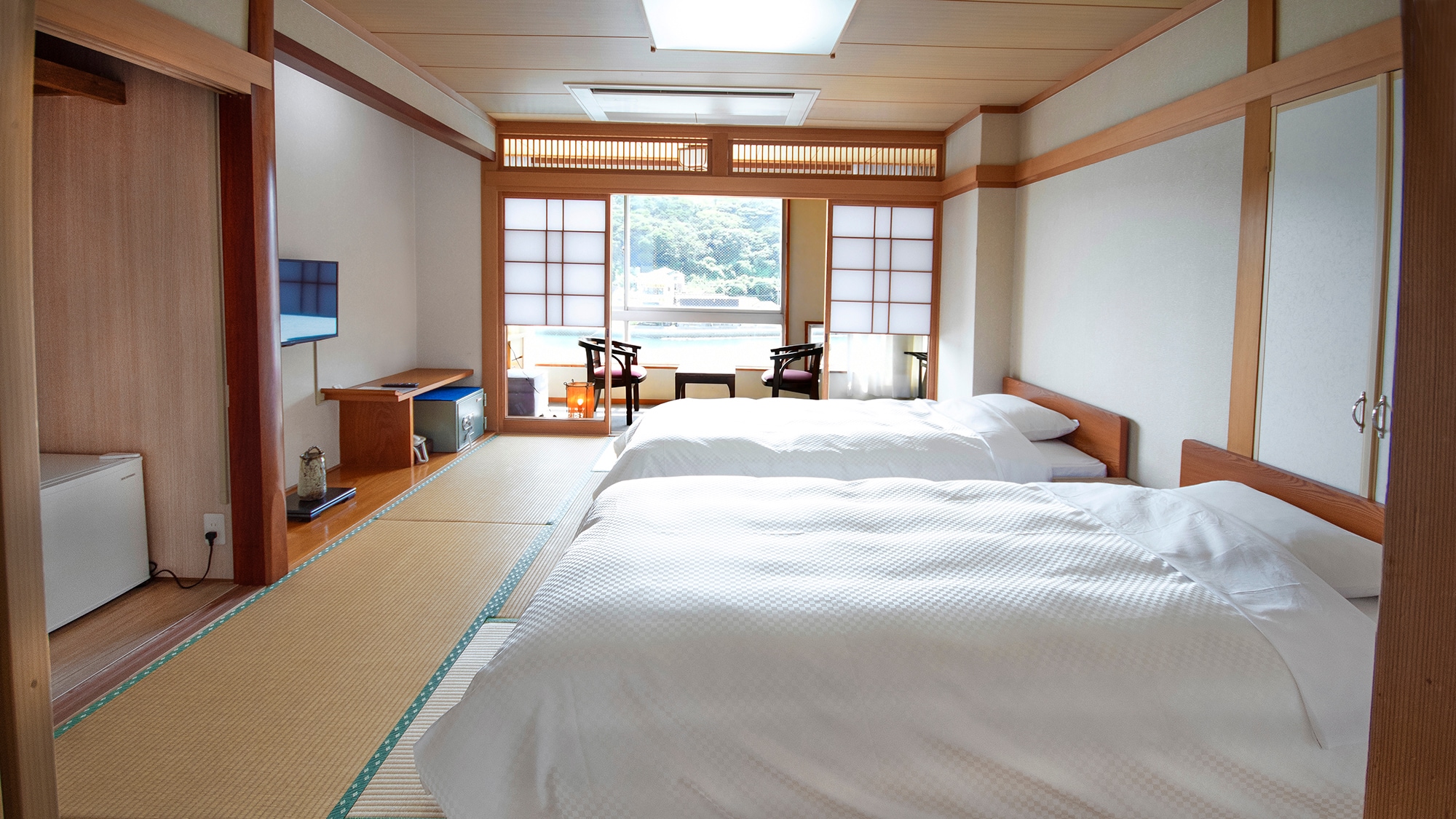 A bed-type Japanese-style room on the top floor. The view is very good, and you can see the port of Yobuko and the Yobuko Ohashi Bridge in the distance.