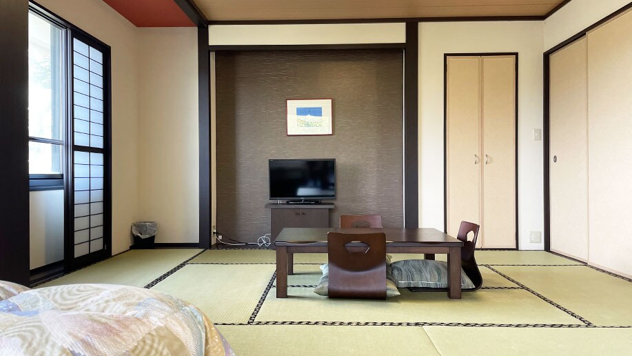 [Example of a Deluxe Family Room] (Mountain side) A room with a spacious bed and tatami mats.