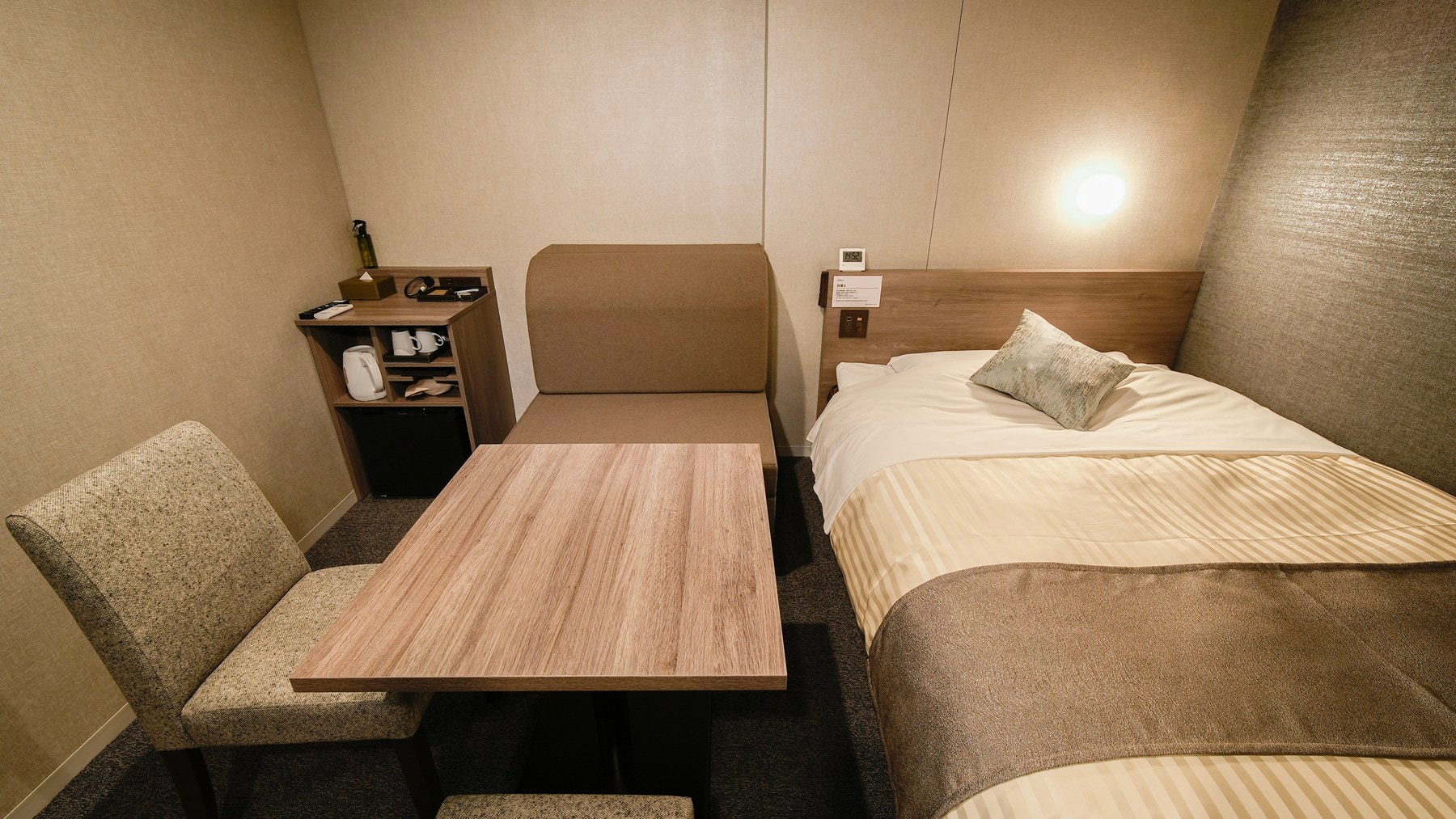 Ini adalah kamar dengan tempat tidur ganda dan sofa.