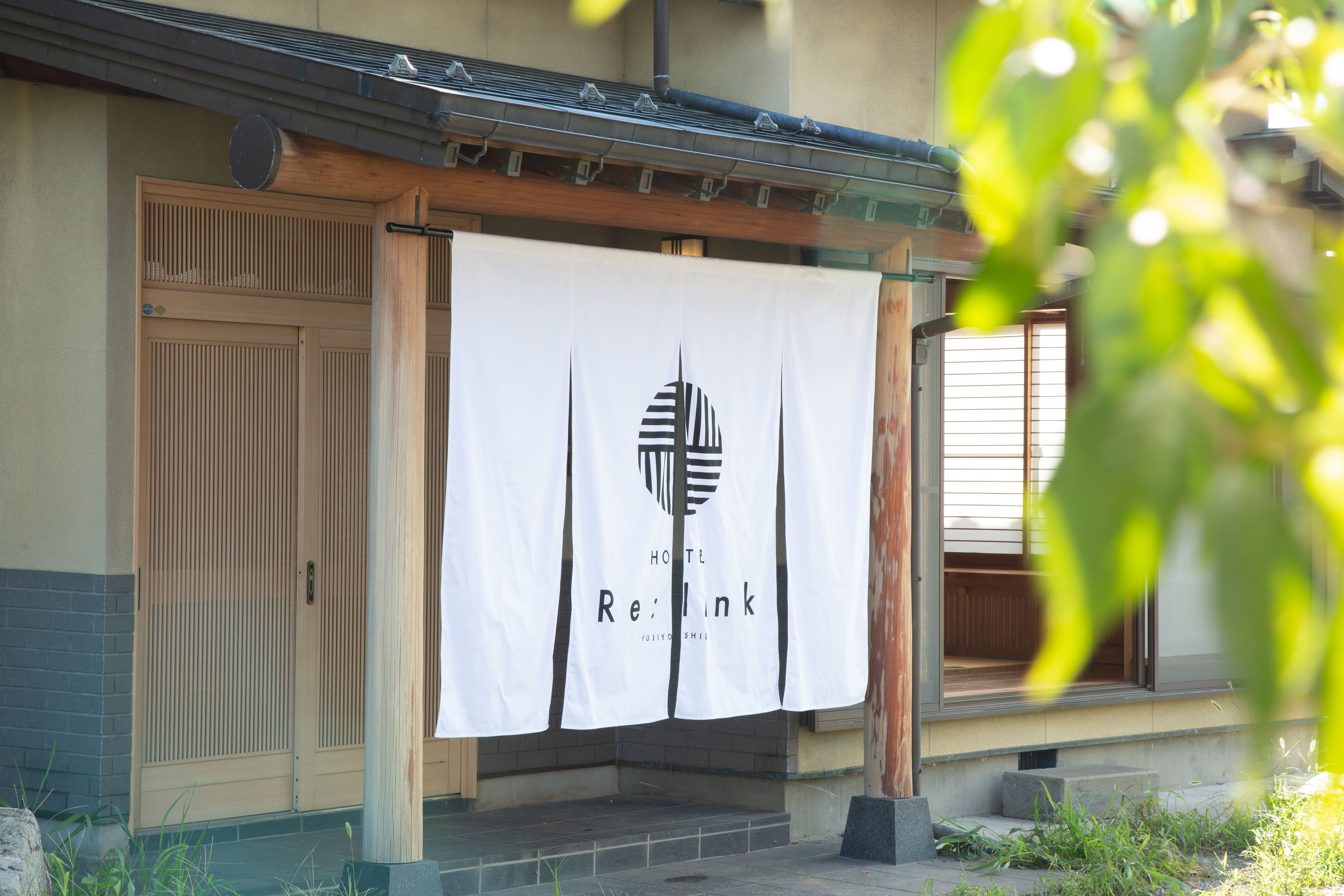The hotel's main entrance is marked by a noren curtain.
