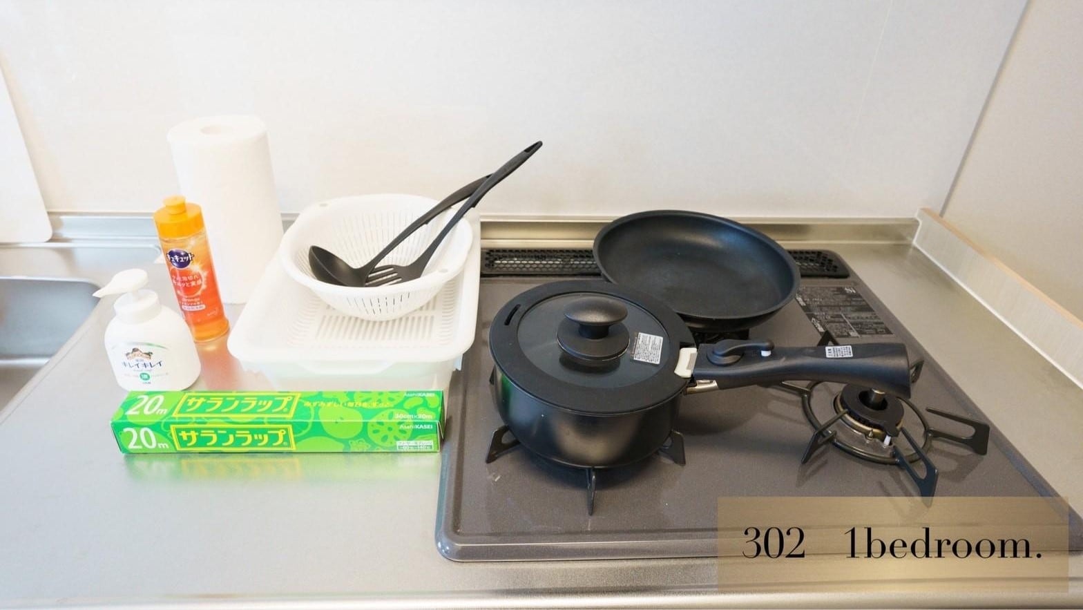 The kitchen is equipped with frying pans, cooking utensils and tableware.