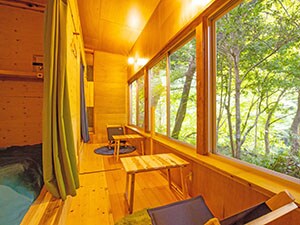 A spacious room made of natural wood with four semi-private beds. Includes a sunken kotatsu seating area!