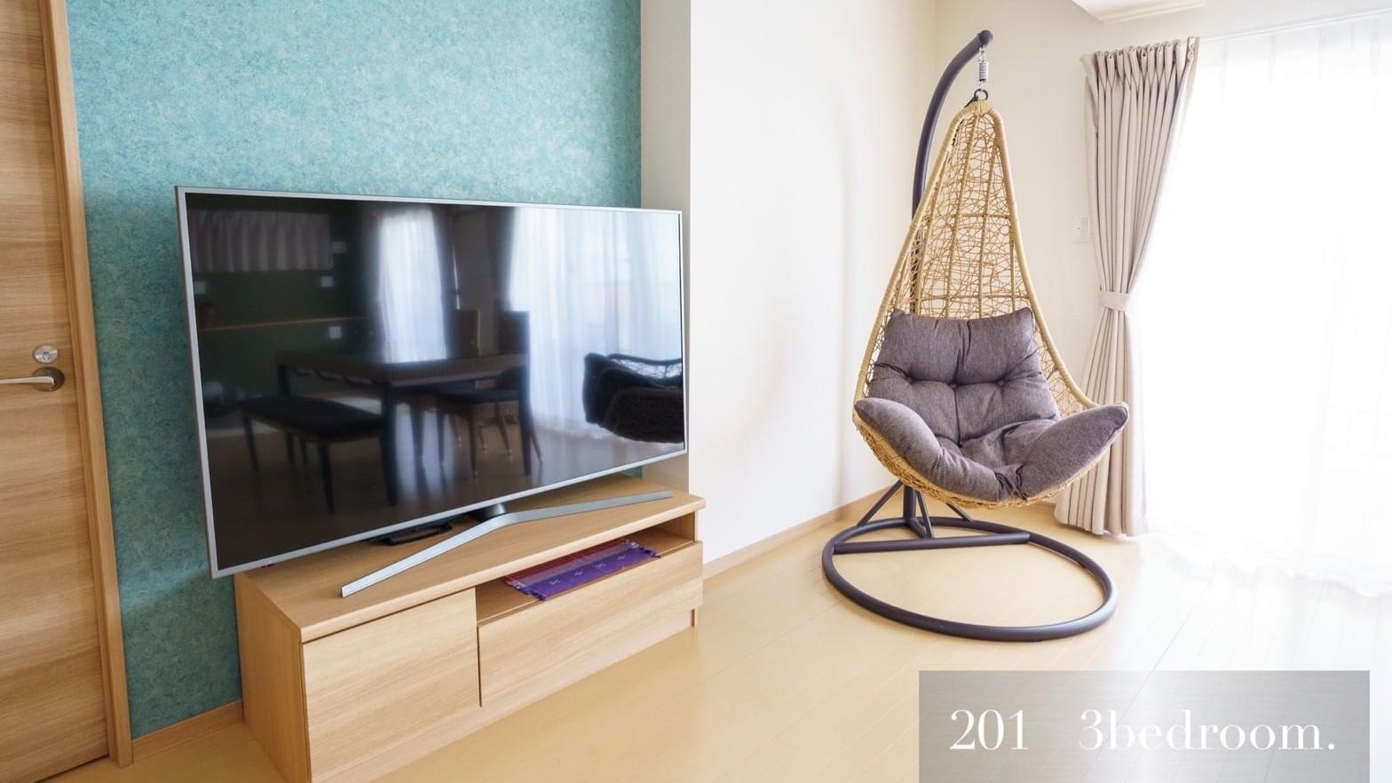 201: The interior is unified with rattan-style furniture, accented with soft shades of green and purple.