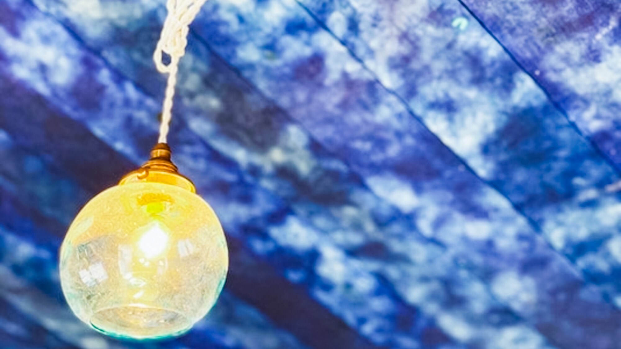 ・[Guest room example] A room with a wooden ceiling covered in indigo-dyed fabric.