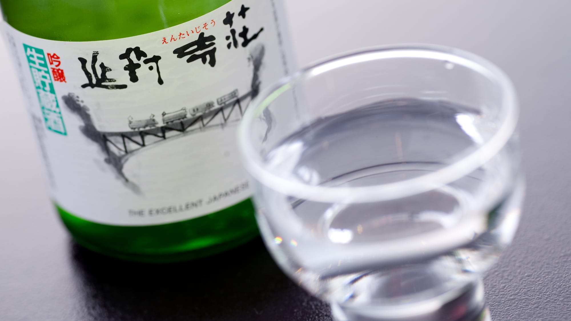 【原創冷酒】標籤上印有圓柱體寺莊的標誌，以及穿越黑部峽谷的有軌電車的圖案。