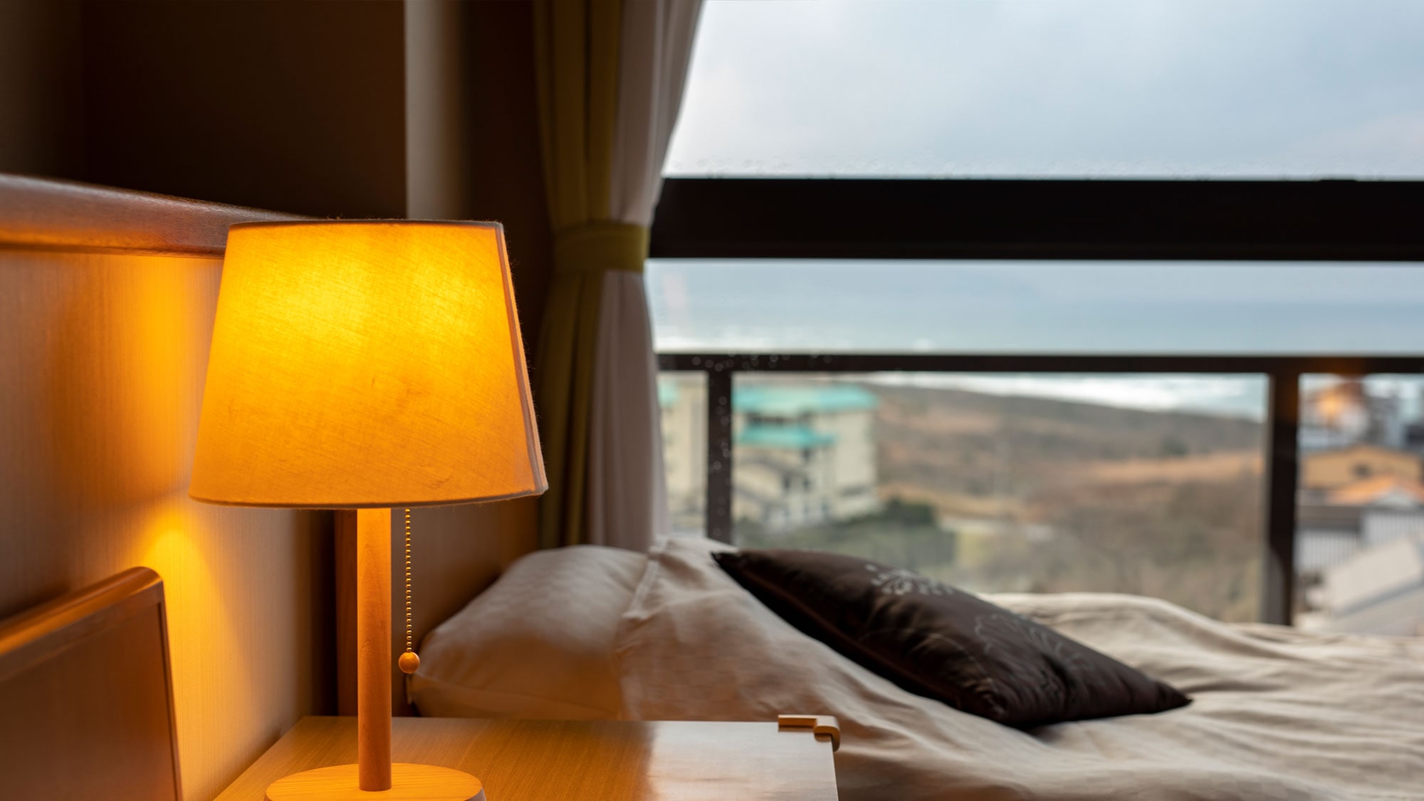 Sebuah lampu redup dan matahari terbenam. Semua kamar di Kasyouen memiliki pemandangan panorama laut.