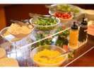 The salad bar offers several types of vegetables.