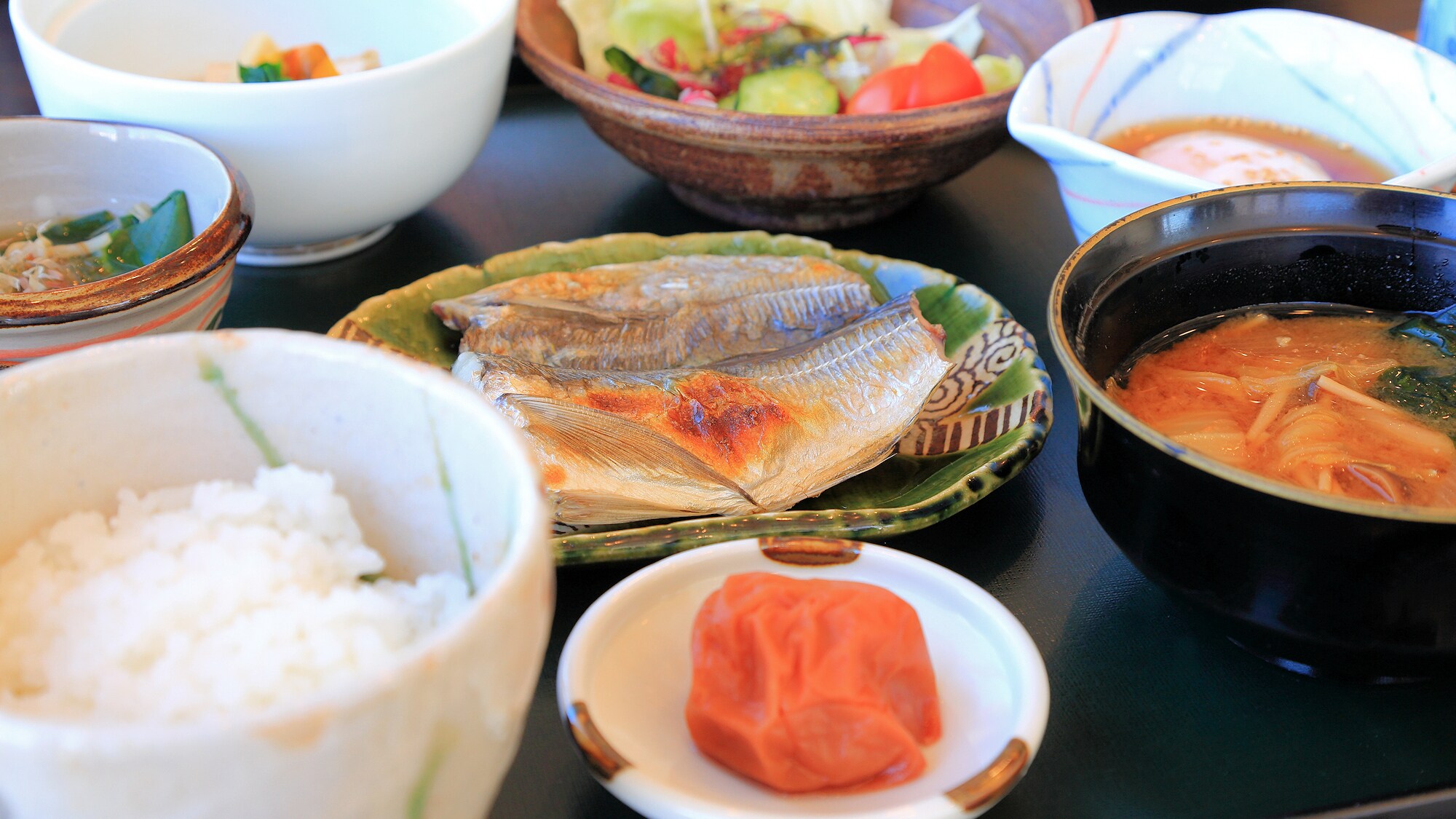 <Cuisine> A traditional Japanese breakfast is served, featuring grilled fish, tofu, and other dishes typical of a ryokan (Japanese inn). Enjoy delicious Koshihikari rice from Ishikawa Prefecture and warm miso soup.