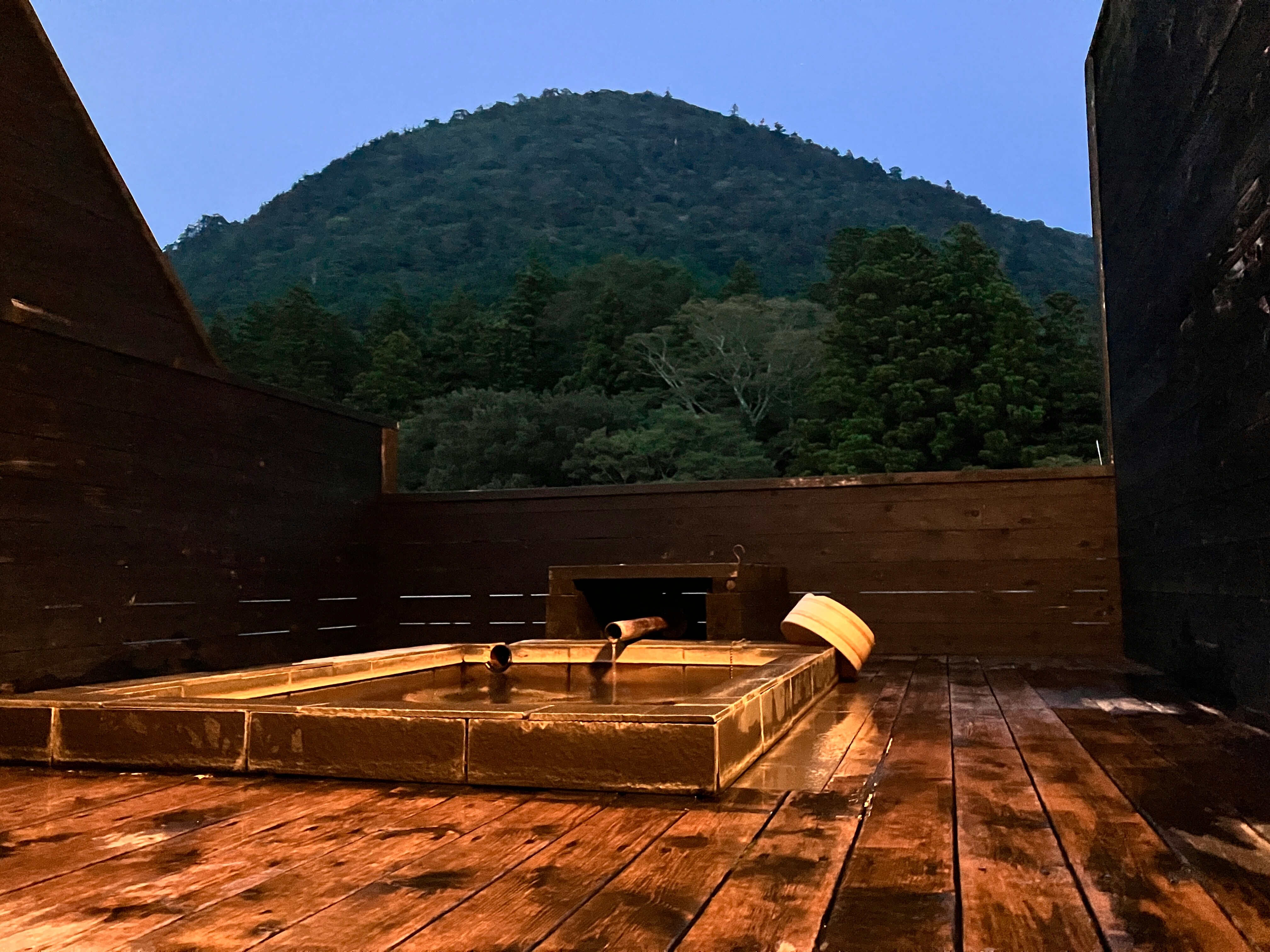 A private open-air bath illuminated at dusk