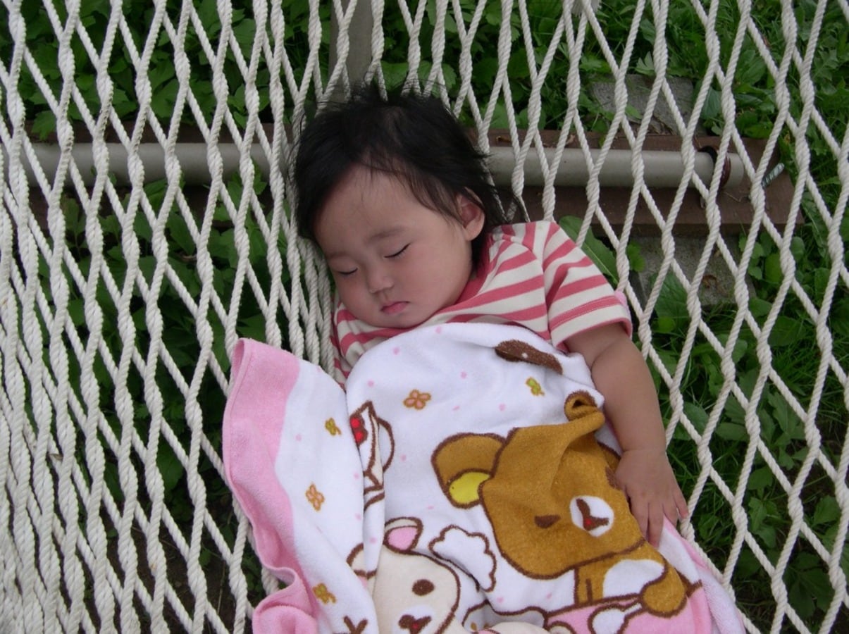 A child sleeping peacefully in a hammock
