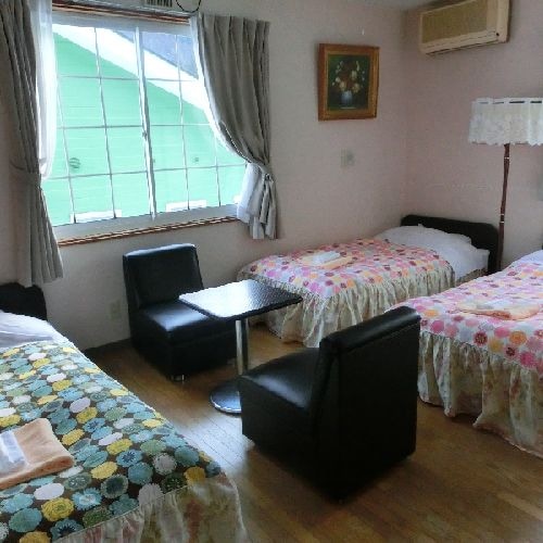 A pension room with a cute bright floral bed cover.