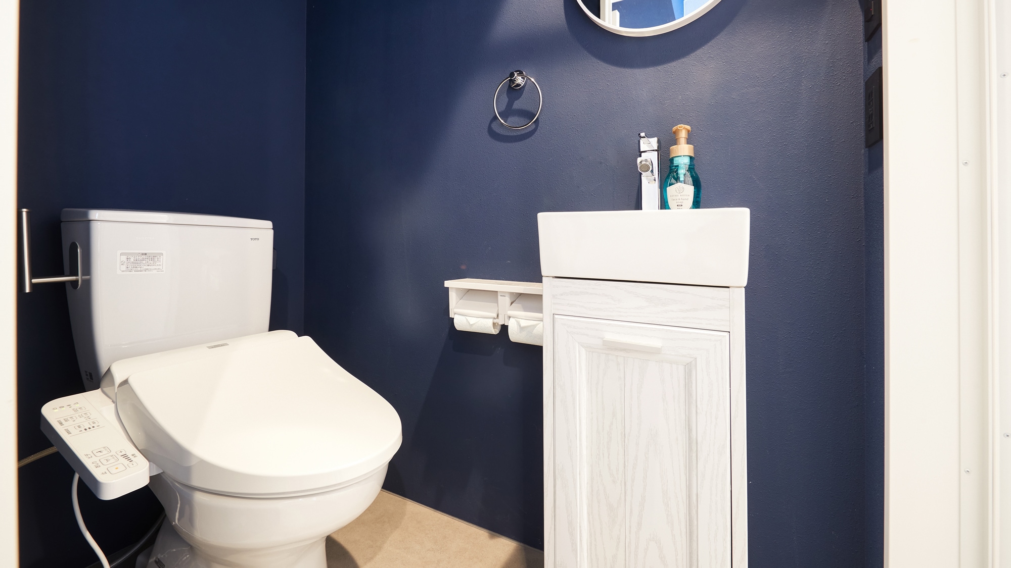 깊은 블루 벽지가 인상적. 심플하면서도 세련된 화장실 공간입니다.