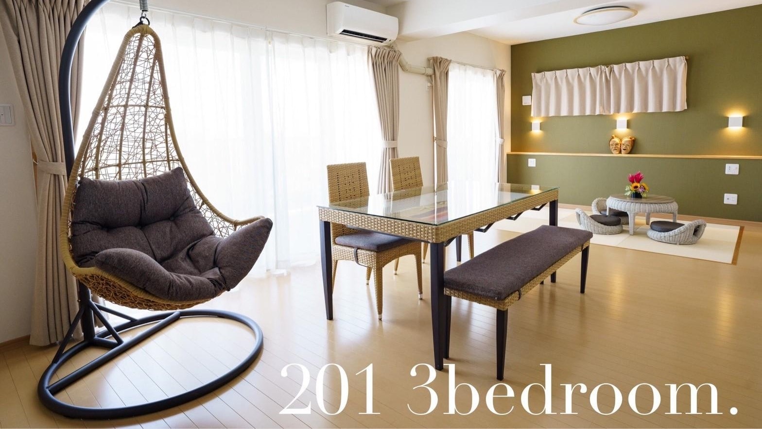 201: The interior is unified with rattan-style furniture, accented with soft shades of green and purple.