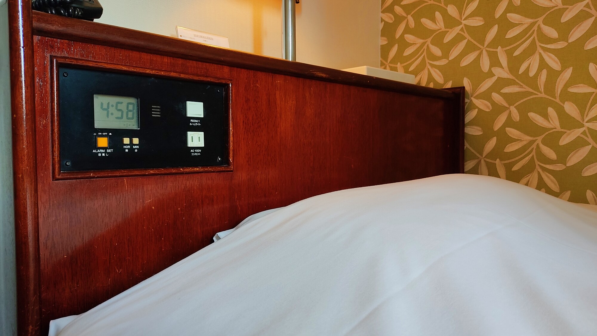 Kamar single dengan stopkontak di samping tempat tidur