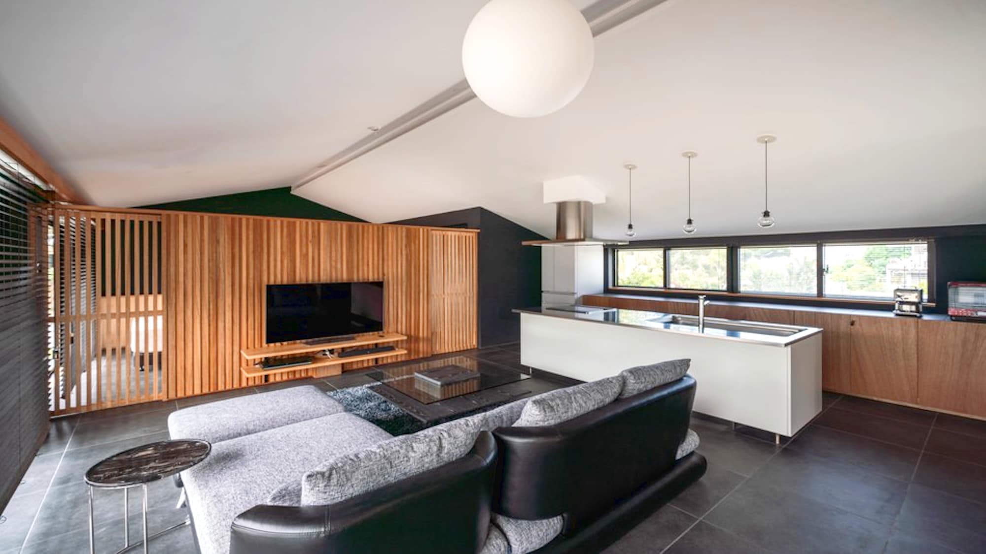 ・The living/dining/kitchen area is designed to resemble a resort hotel. The floor is tiled and the walls are all black.