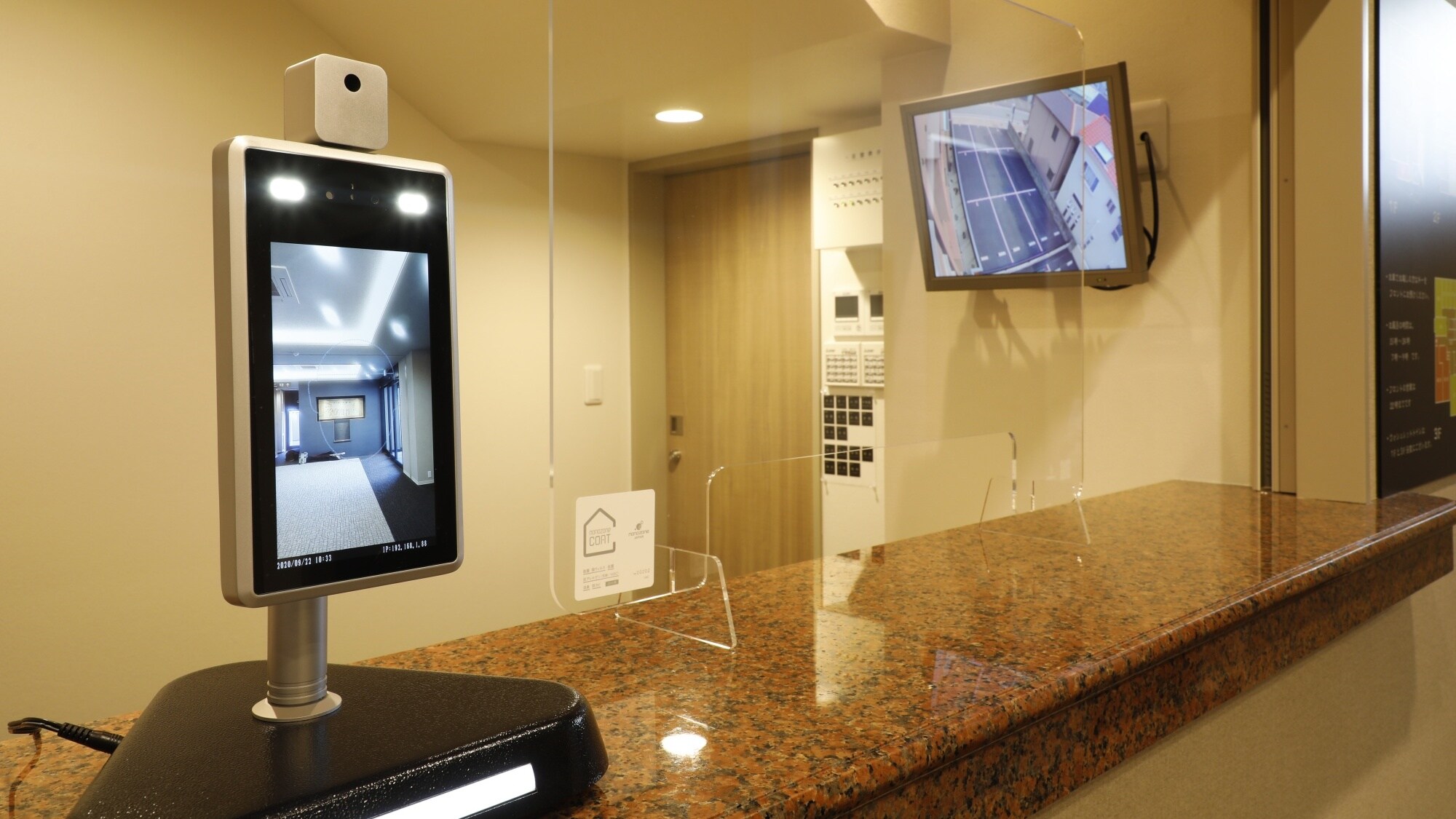 [Di dalam gedung (meja resepsionis dan lobi)] Kamera termal dipasang di meja resepsionis.