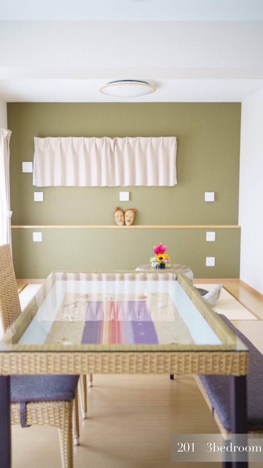201: The interior is unified with rattan-style furniture, accented with soft shades of green and purple.
