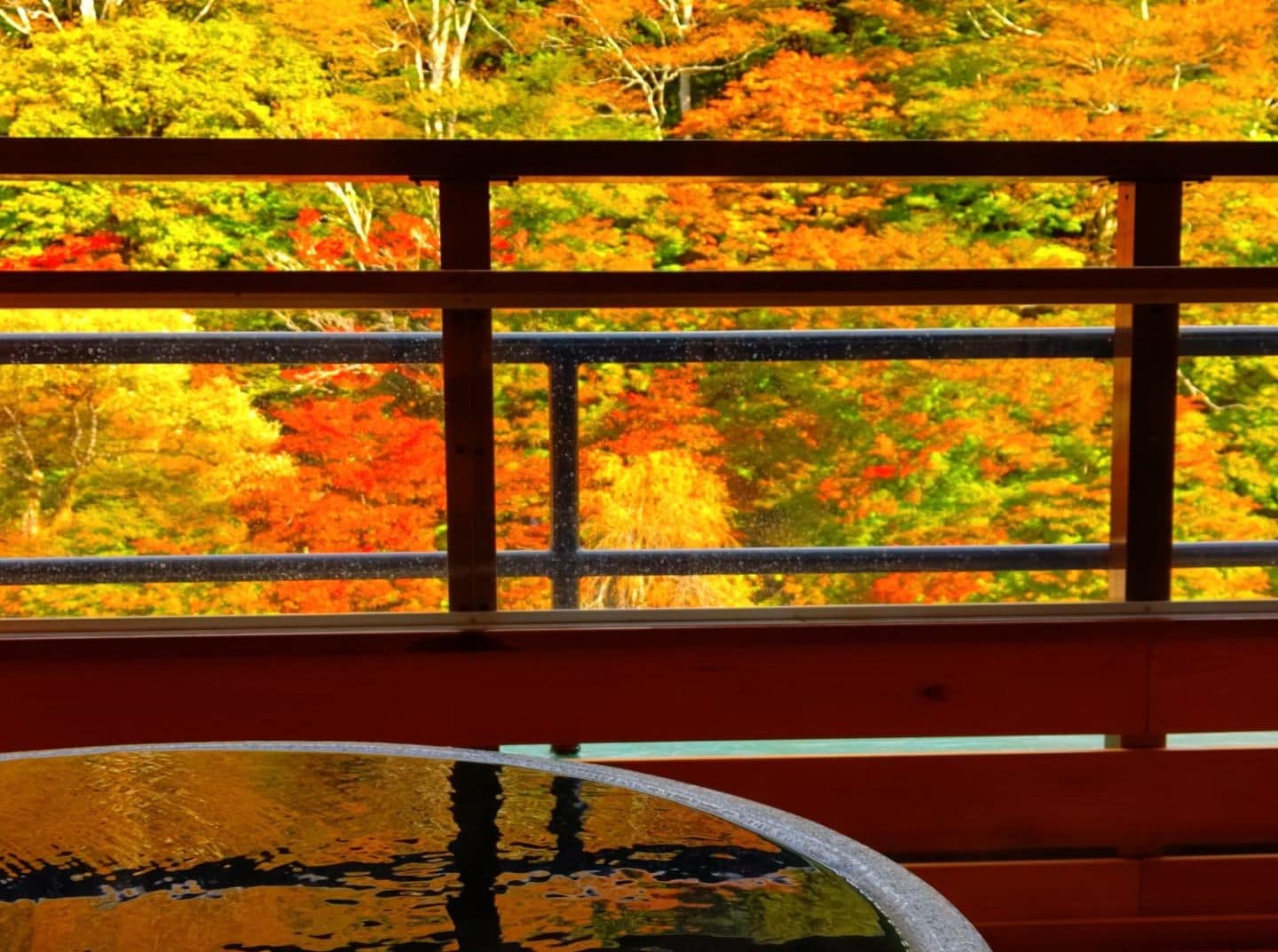 View from the ceramic bath in a guest room with an open-air bath during autumn foliage season