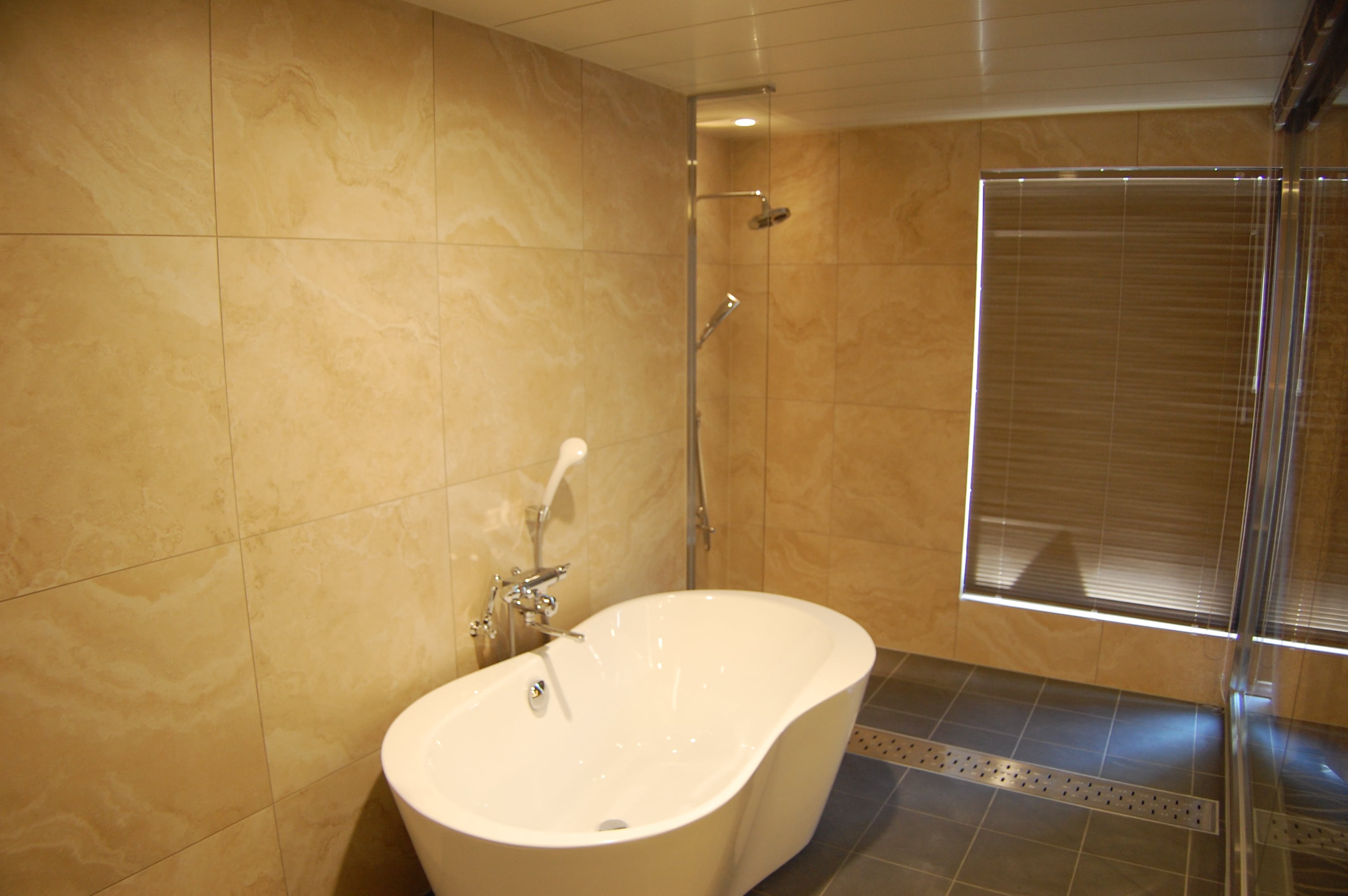 Bathroom in the suite, stylish bathtub and overhead shower
