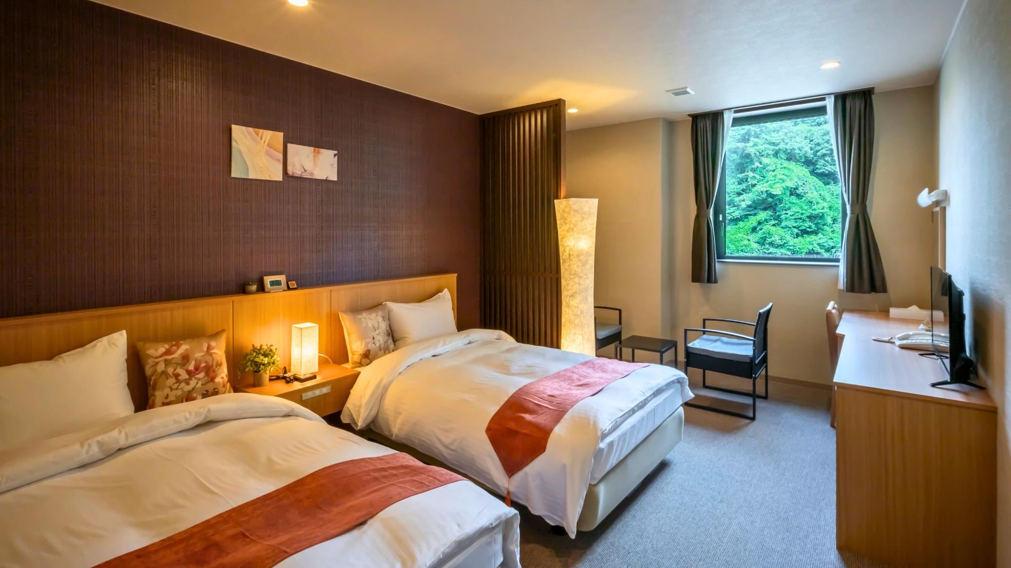 A comfort twin room with a chair and table set, "Japanese modern." Enjoy a chat while gazing at the greenery by the window.