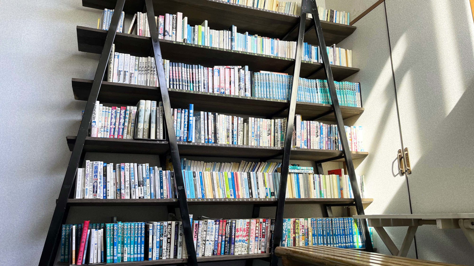 Ada pojok baca manga dan novel di tangga.